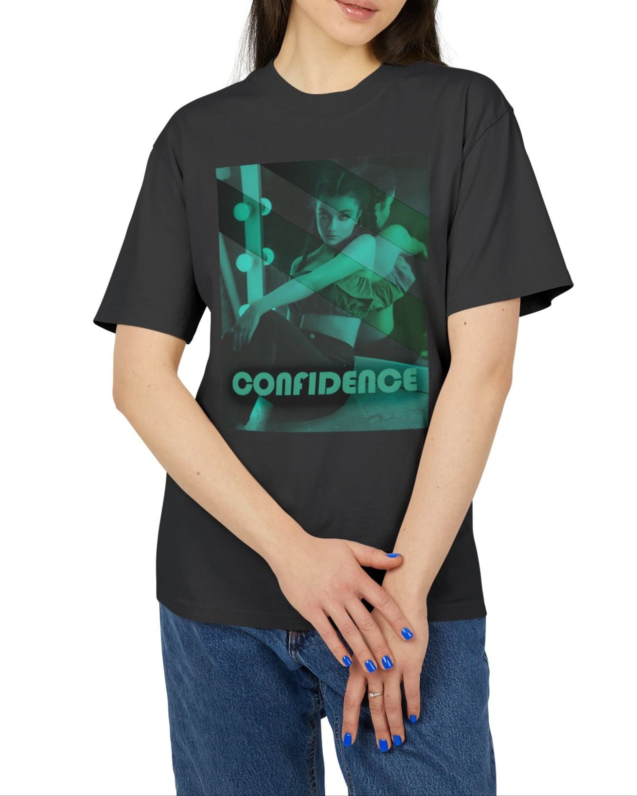 Unisex heavy carded cotton T-shirt in faded black with a boxy fit, featuring a woman who sits in front of a softly lit vanity mirror, framed by diagonal tones of pine and sea green. Her expression is poised and calm, capturing quiet confidence without performance. From ModeK Vetements.