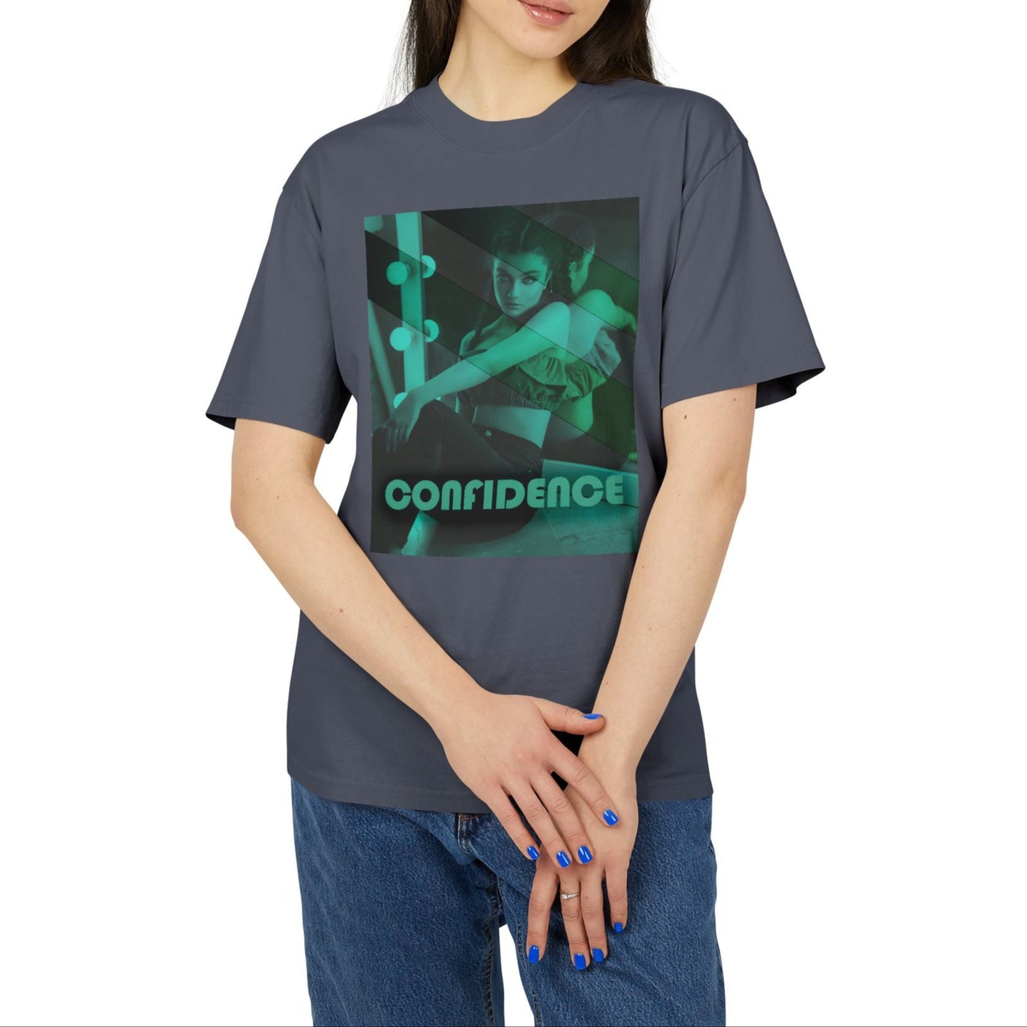 Unisex heavy carded cotton T-shirt in faded indigo with a boxy fit, featuring a woman who sits in front of a softly lit vanity mirror, framed by diagonal tones of pine and sea green. Her expression is poised and calm, capturing quiet confidence without performance. From ModeK Vetements.