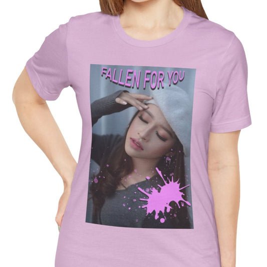 Unisex T-shirt in lilac, featuring a dreamy photo of a woman with closed eyes, a soft expression, and a pink paint splash over her chest. The words “FALLEN FOR YOU” appear in bold pink lettering at the top. ModeK Vetements.