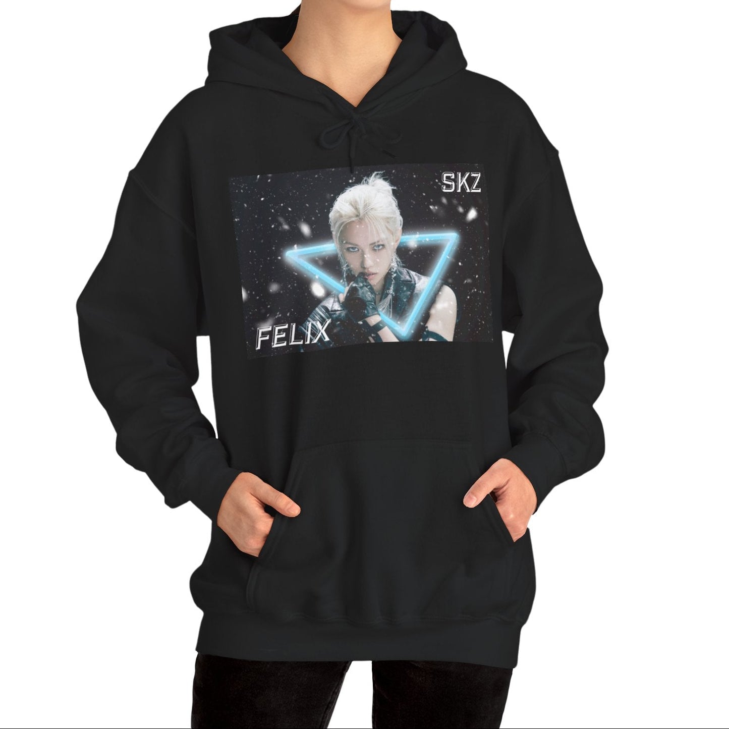 Unisex cotton-poly blend hoodie in black, featuring a visual print of Felix from Stray Kids, framed by a glowing blue neon triangle amid falling snow on a dark background. From ModeK Vetements.