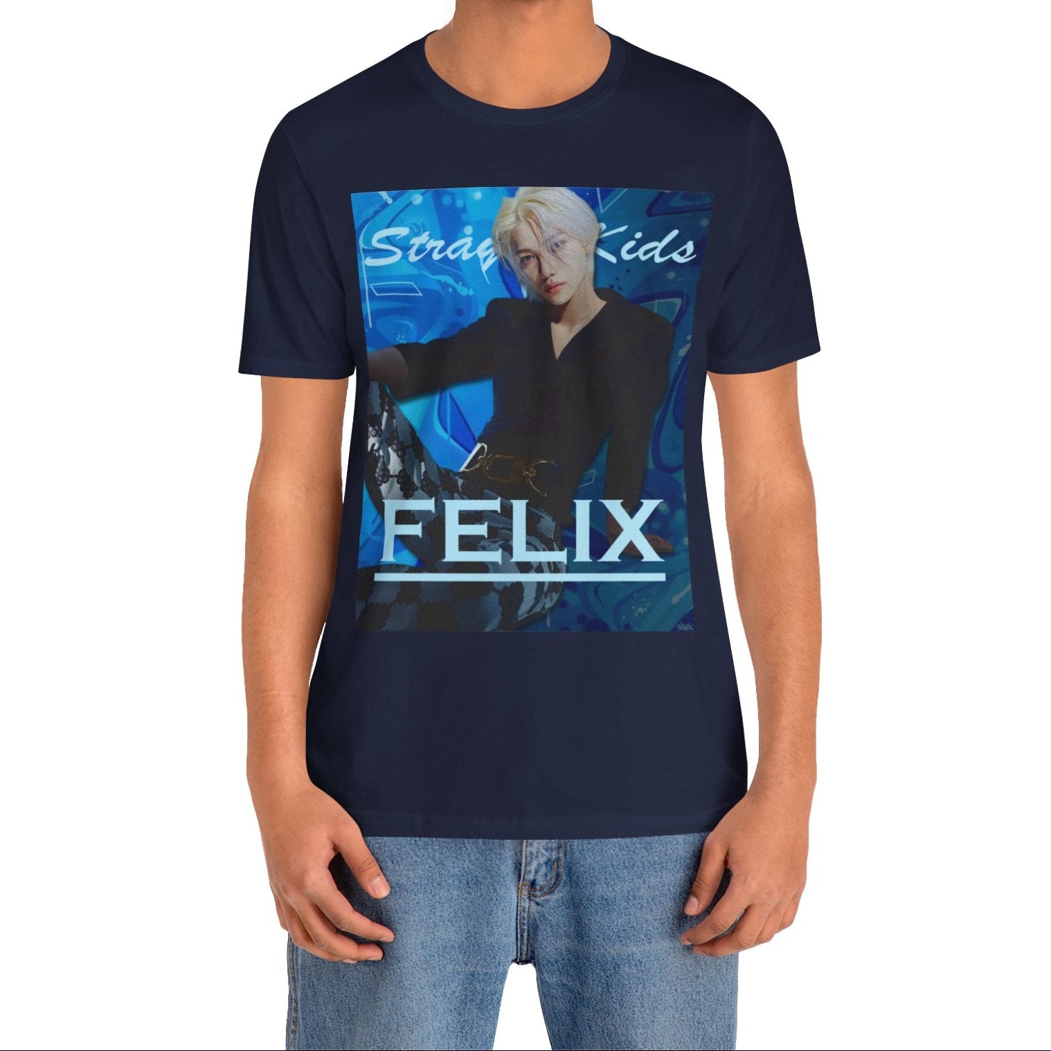 Male model showcasing the unisex, 100% airlume combed & ring-spun cotton t-shirt in navy, featuring a graphic design. It shows Felix from Stray Kids in a provocative pose, wearing a structured black suit jacket and oriental-style patterned pants. The background is a multi-toned blue graffiti. From ModeK Vetements.
