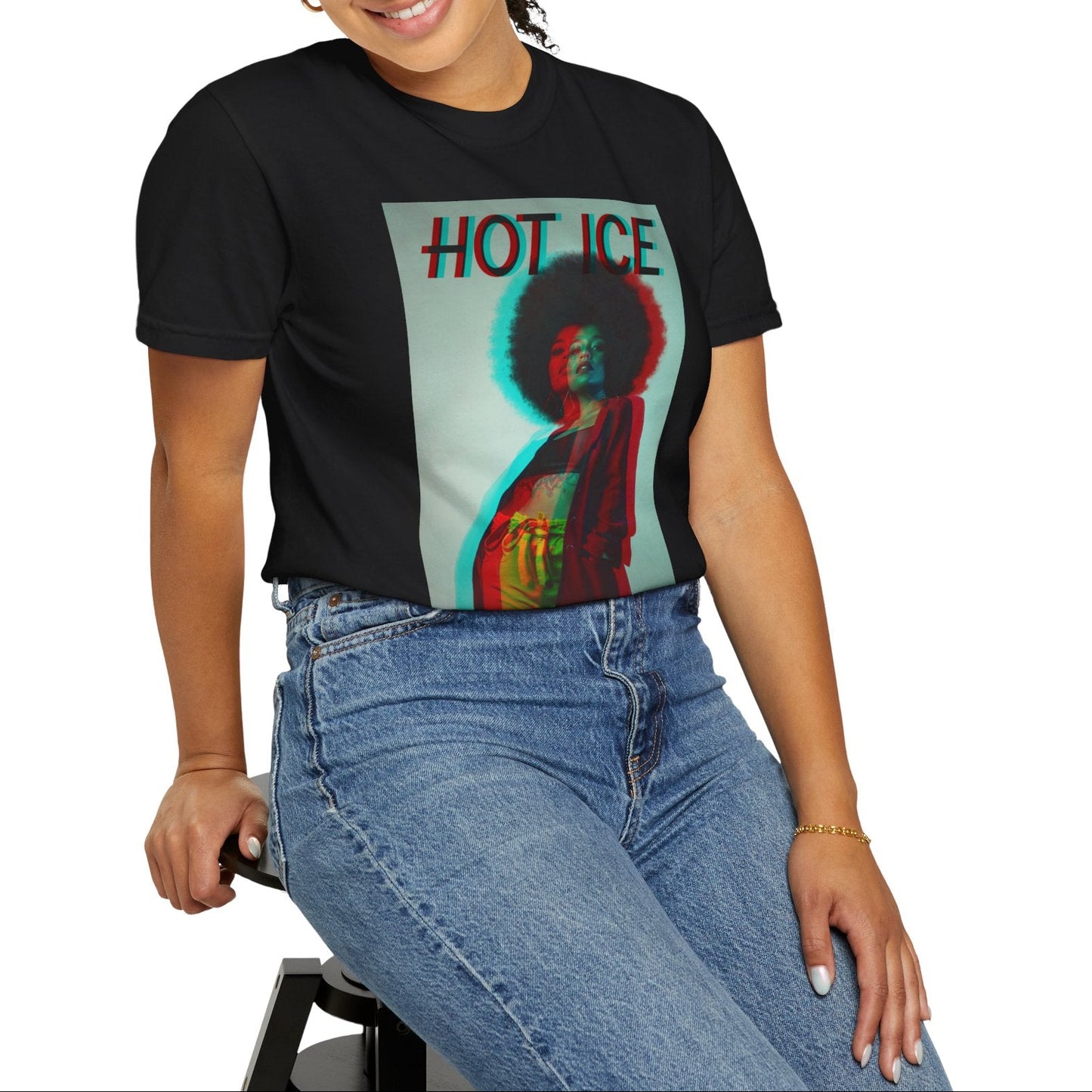 Model sitting on a stool and showcasing the HOT ICE unisex T-Shirt in black featuring a 3D glitch effect with red and blue overlays, retro-futuristic digital distortion, and bold typography. 100% ringspun cotton from ModeK Vetements.