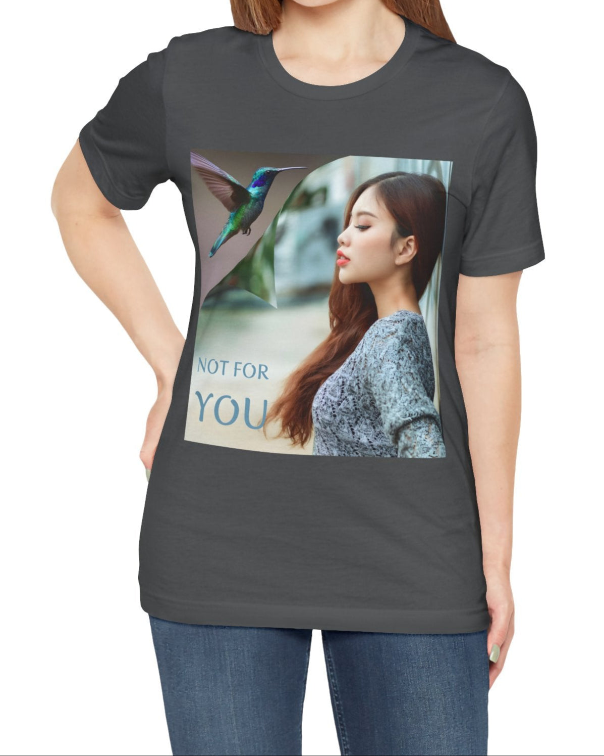 Unisex airlume combed, ring-spun cotton T-shirt in asphalt, featuring a turning-page effect that reveals a hummingbird in flight. Inspired by the lightness, color, and serenity of the bird, the design evokes grace, freedom, and a soul that seeks only the nectar of life. From ModeK Vetements.