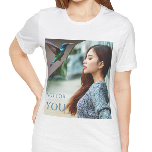 Unisex airlume combed, ring-spun cotton T-shirt in white, featuring a turning-page effect that reveals a hummingbird in flight. Inspired by the lightness, color, and serenity of the bird, the design evokes grace, freedom, and a soul that seeks only the nectar of life. From ModeK Vetements.