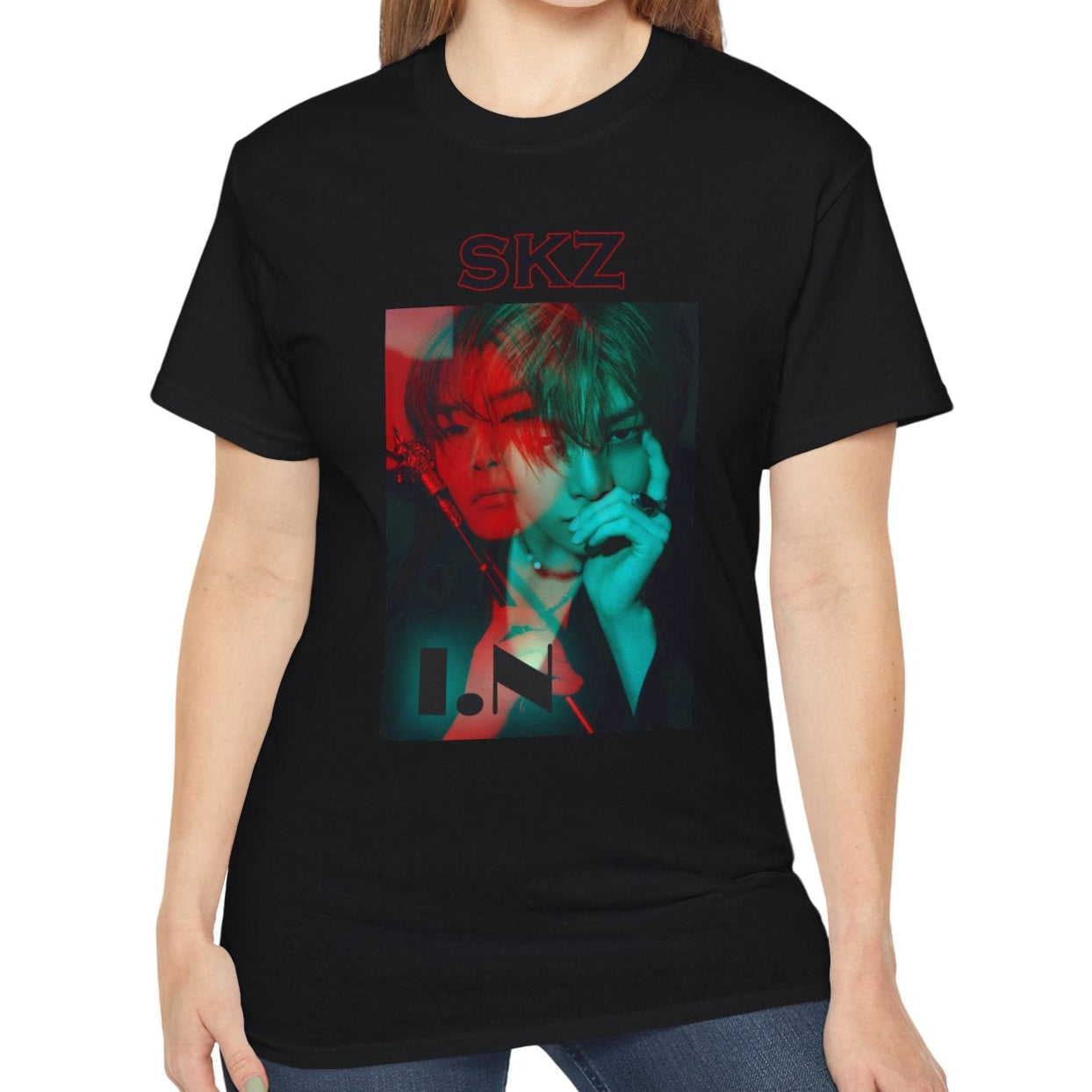 I.N Stray Kids unisex T-shirt in black, featuring a bold black-and-white portrait with a dual-tone red and teal overlay. The striking 3D-like effect, combined with "SKZ" typography and I.N’s name, creates a modern, edgy aesthetic. Made from 100% cotton for lightweight comfort. From ModeKVetements.