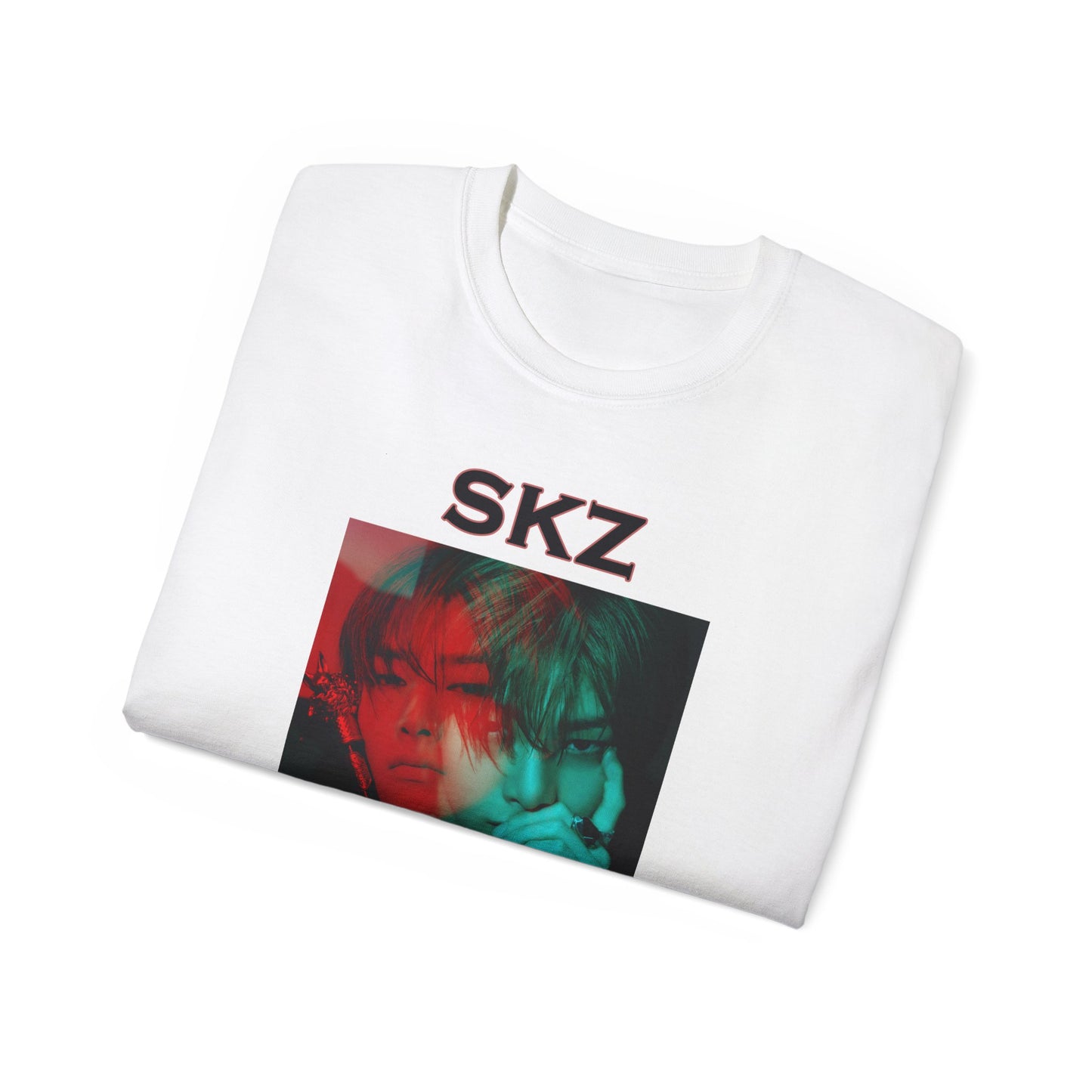 Folded I.N Stray Kids unisex T-shirt in white, featuring a bold black-and-white portrait with a dual-tone red and teal overlay. The striking 3D-like effect, combined with "SKZ" typography and I.N’s name, creates a modern, edgy aesthetic. Made from 100% cotton for lightweight comfort. From ModeKVetements.