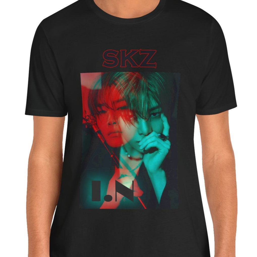 I.N Stray Kids unisex T-shirt in black, featuring a bold black-and-white portrait with a dual-tone red and teal overlay. The striking 3D-like effect, combined with "SKZ" typography and I.N’s name, creates a modern, edgy aesthetic. Made from 100% Airlume cotton for lightweight comfort. From ModeKVetements.