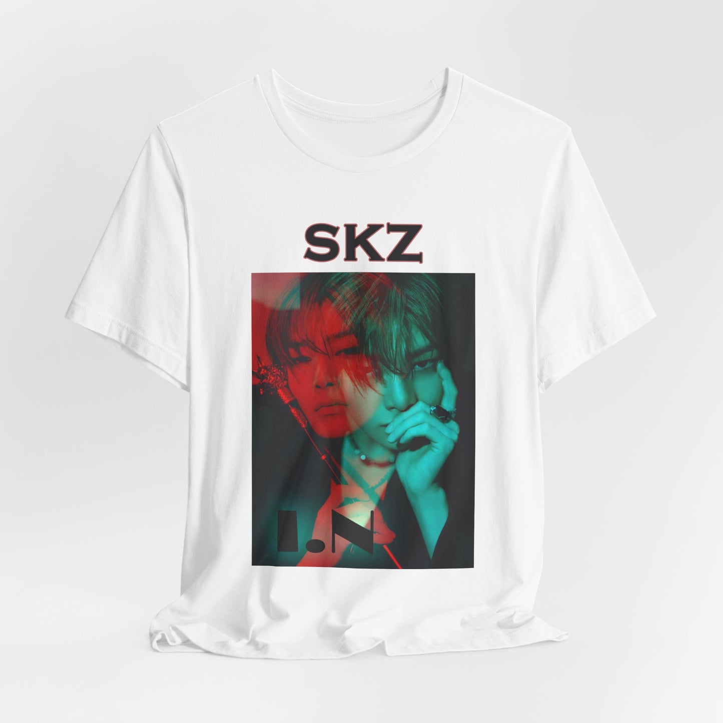 I.N Stray Kids unisex T-shirt in white, displayed in a relaxed draped style. Features a bold black-and-white portrait with a striking red and teal dual-tone overlay, creating a dynamic, futuristic aesthetic. Made from 100% Airlume cotton for lightweight comfort. From ModeKVetements.