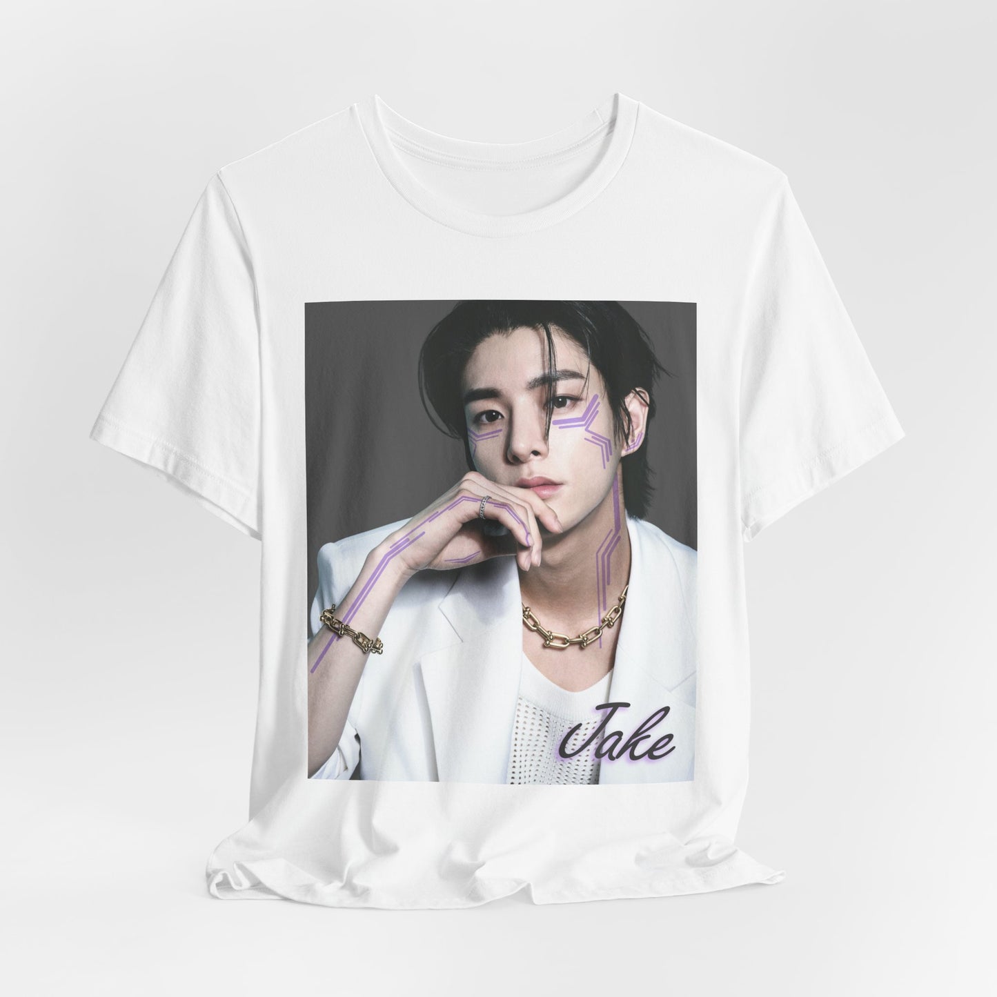 Unisex draped T-shirt in white, featuring a print of Jake from ENHYPEN wearing a white jacket with notch lapels and a mesh knit shirt, adorned with bold gold chains and delicate light wisteria circuit-like tattoos emphasizing his cheekbones and jawline. ModeK Vetements.