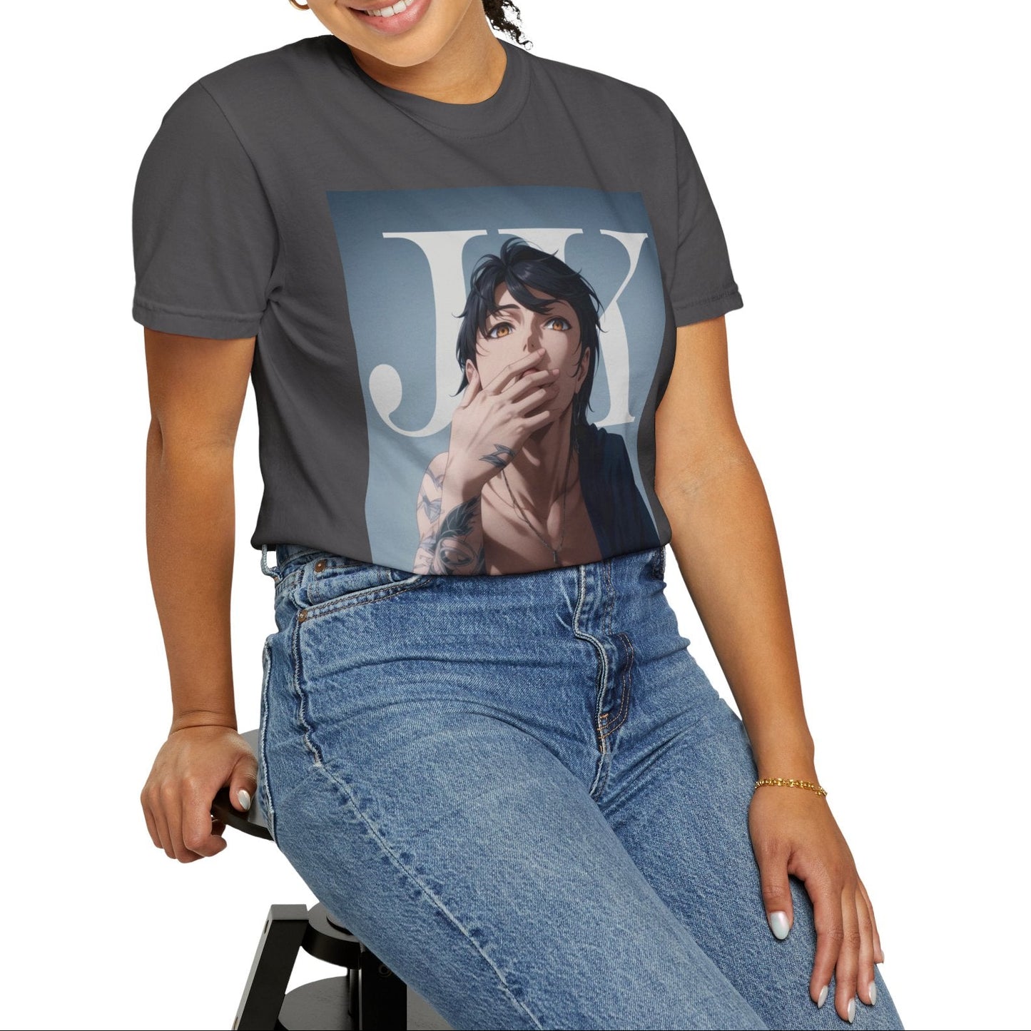 Model sitting on a stool and showcasing the Anime-style unisex T-shirt in graphite, featuring Jungkook, blending K-pop stage presence with anime aesthetics. The design captures his intense gaze, flowing hair, and striking composition, creating a fusion of two beloved art forms. Printed on soft, breathable ring-spun cotton for comfort and style. ModeK Vetements.