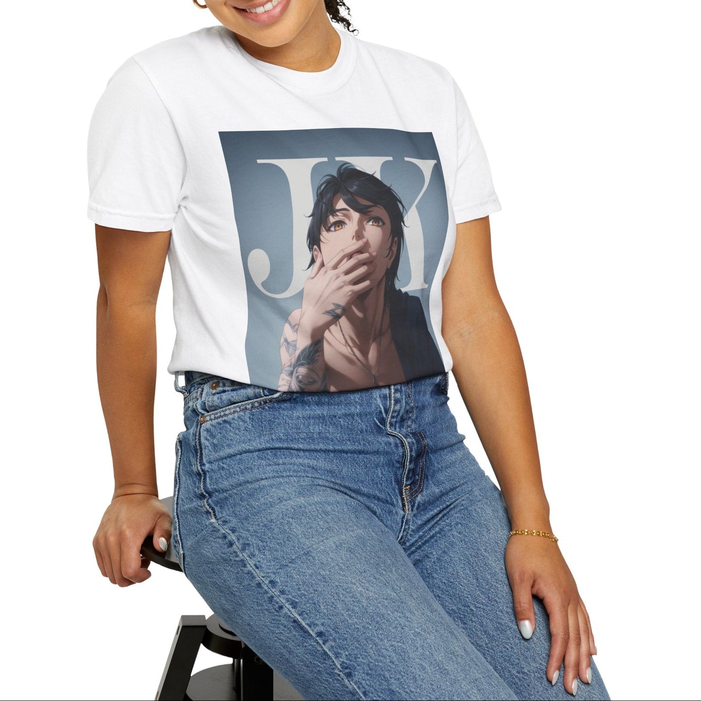 Model sitting on a stool and showcasing the Anime-style unisex T-shirt in white, featuring Jungkook, blending K-pop stage presence with anime aesthetics. The design captures his intense gaze, flowing hair, and striking composition, creating a fusion of two beloved art forms. Printed on soft, breathable ring-spun cotton for comfort and style. ModeK Vetements.
