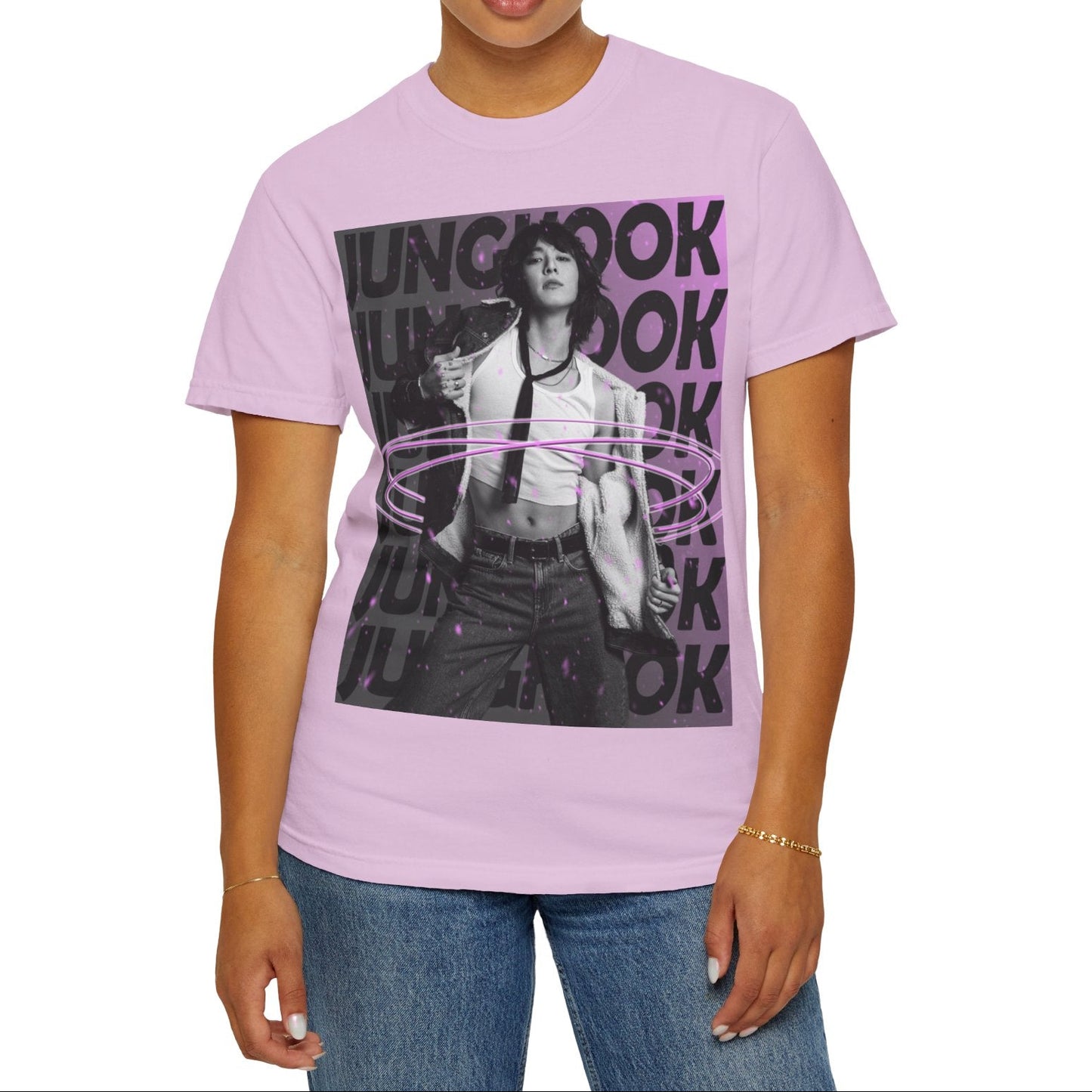 Unisex 100% ring-spun cotton T-Shirt in orchid, featuring BTS's Jungkook. He is posing against a dark background with "JUNGKOOK" repeated in large black typography and a charcoal-lavender gradient with pink paint splatters. Three glowing, thin magenta hoops encircle his waist, creating a sense of motion, making him even more provocative. From ModeK Vetements.