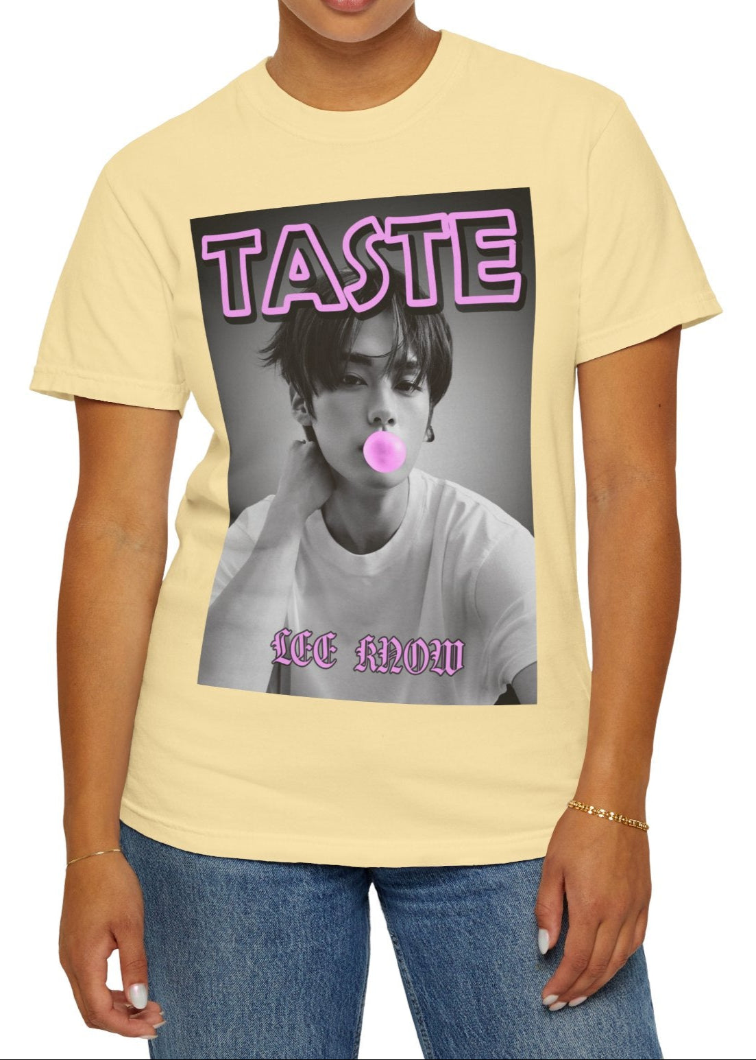 Lee Know Stray Kids Unisex T-Shirt in banana – The Taste of Mischief. A stylish monochrome design featuring Lee Know blowing a pink bubble gum bubble. The bold pink and purple "TASTE" text adds a playful yet edgy touch, referencing both the candy-like fun and his song “Taste.” ModeK Vetements.