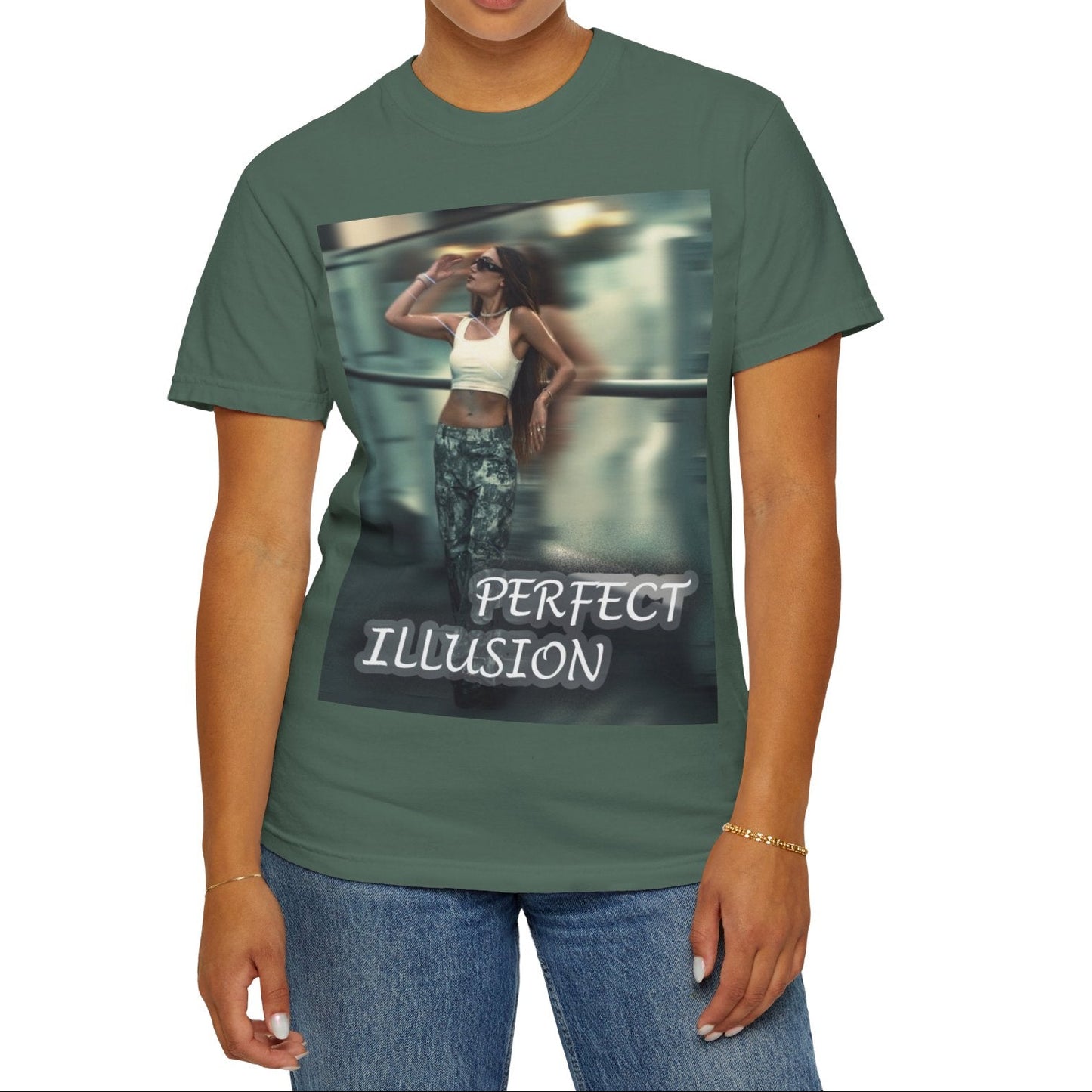 Unisex 100% ring-spun cotton t-shirt in blue spruce, featuring a graphic design, where a woman in tactical camo cargo pants and a white crop top stands as a sharp anchor against a blurry, cinematic urban background. The design also features a digital dispersion effect and electric blue rays, symbolizing the "Perfect Illusion" where brute force hides a deeper reality of tenderness and beauty. From ModeK Vetements.