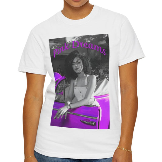 Unisex T-shirt in white, made from 100% ring-spun cotton featuring a printed design where a pinkish purple race car dominates a monochrome scene, with a girl leaning calmly against it. The words “Pink Dreams” curve above, evoking attitude, stillness, and the feeling of living on her own terms. From ModeK Vetements.