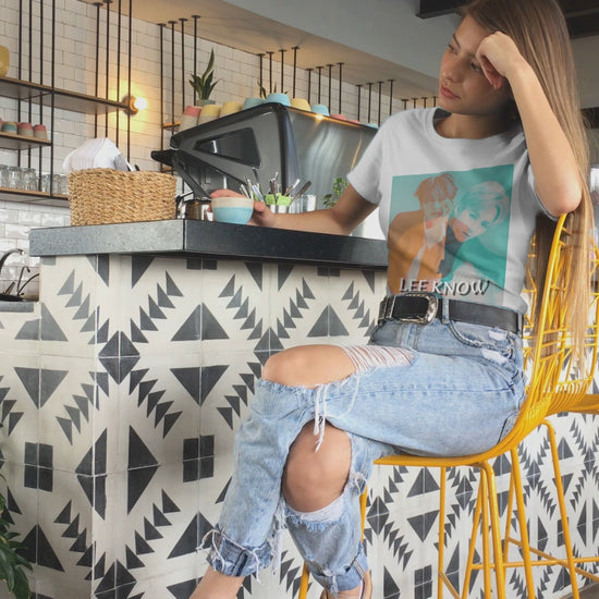 Video showcasing the Lee Know SKZ unisex T-shirt in white, with a bold double-exposure design in teal and tangerine tones. Features layered portraits and soft cotton fabric. ModeK Vetements.