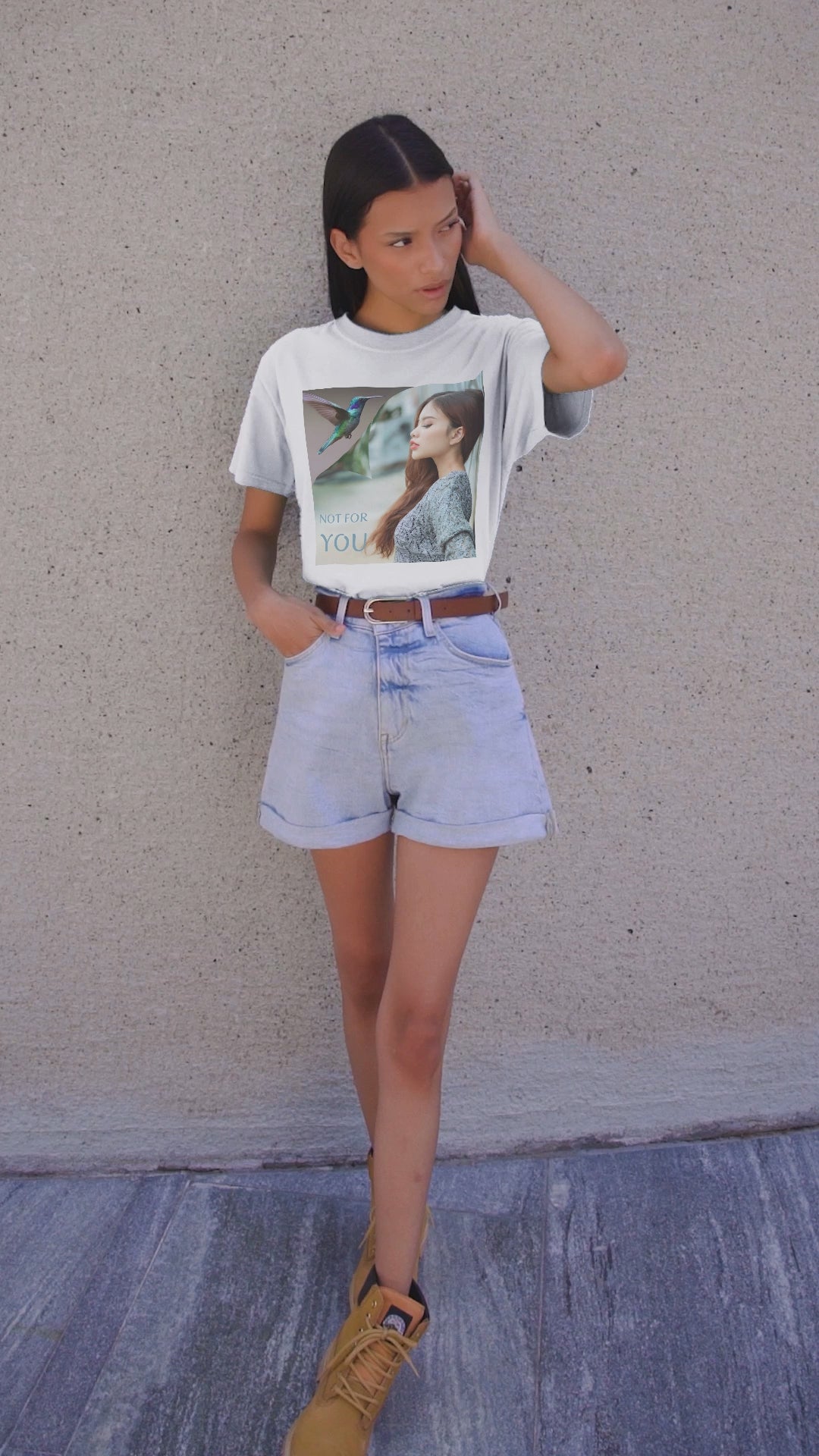 Video showcasing the Unisex airlume combed, ring-spun cotton T-shirt in white, featuring a turning-page effect that reveals a hummingbird in flight. Inspired by the lightness, color, and serenity of the bird, the design evokes grace, freedom, and a soul that seeks only the nectar of life. From ModeK Vetements.