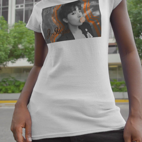 Video showcasing the Black-and-white portrait of J-Hope of BTS blowing peach bubblegum, accented with bold deep orange contour lines — playful and bold design on a unisex cotton T-shirt in white. ModeK Vetements.