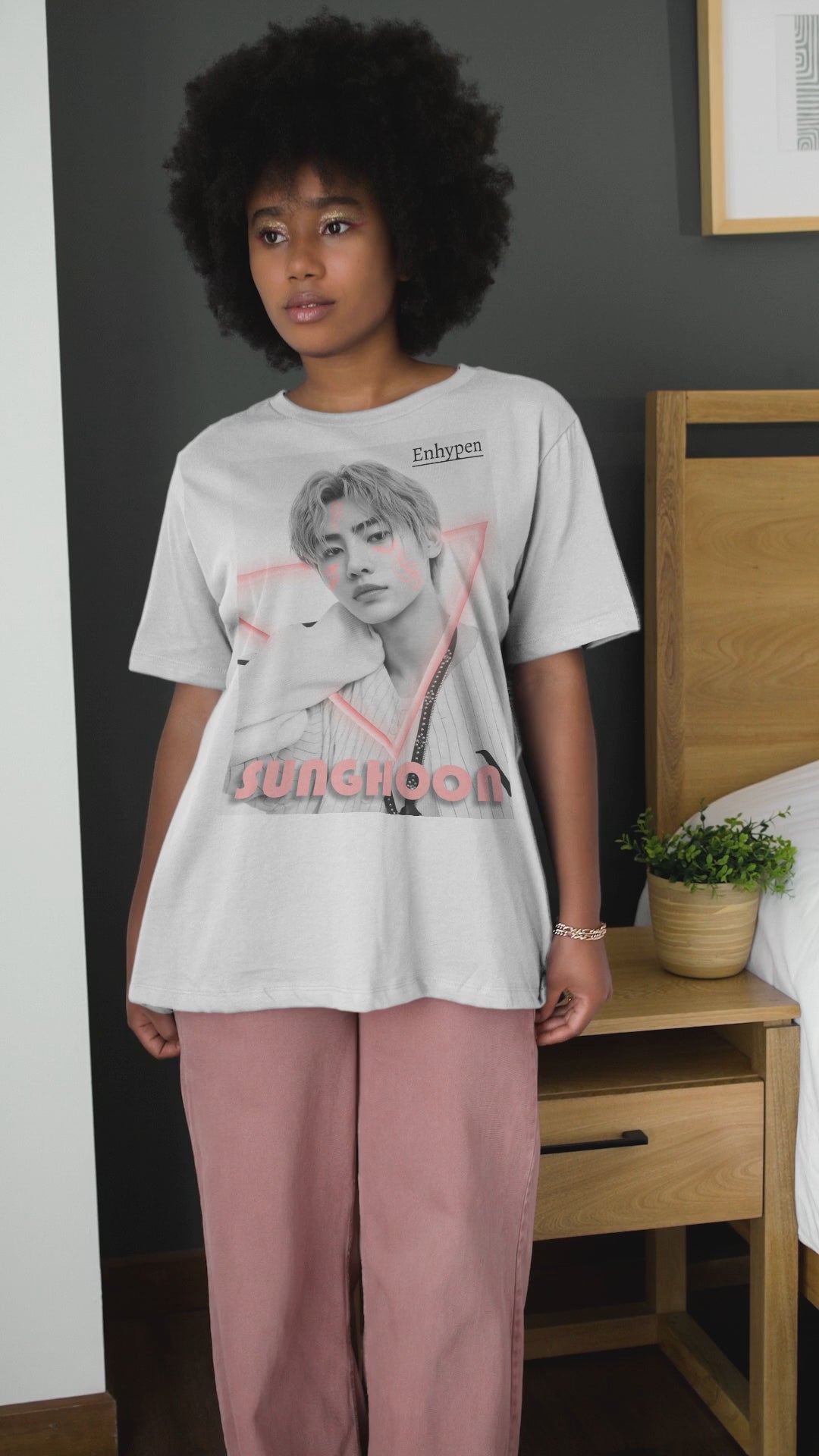 Video showcasing the Unisex oversized heavy cotton T-shirt in white, featuring Sunghoon of ENHYPEN in a synthwave-inspired design with cornflower lilac neon triangle, geometrical face tattoos, and vintage font. From ModeK Vetements.