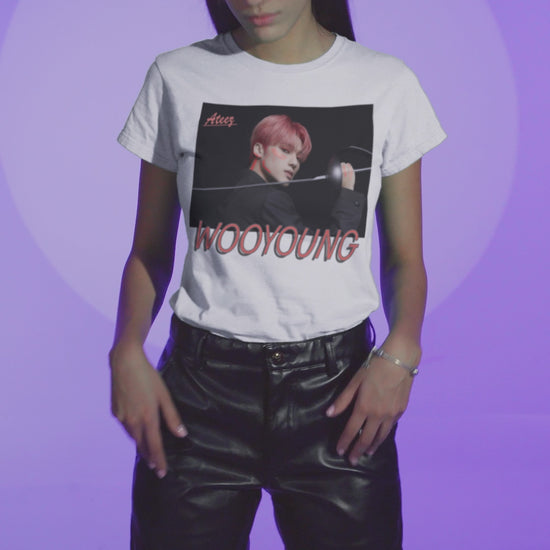 Video showcasing the Wooyoung ATEEZ Unisex T-Shirt featuring a striking design of Wooyoung wielding a sword, his pink-red hair and sharp cheekbones illuminated by dynamic lighting. A must-have for ATINY.