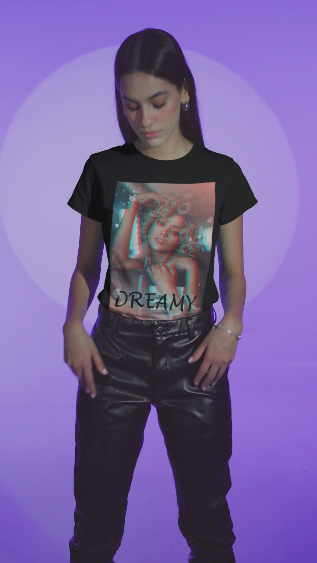 Video showcasing the Unisex 100% ring-spun cotton T-Shirt in black featuring a DTG graphic design: a stylized anaglyph portrait of a woman with curly hair, leaning on an electronic keyboard. The design uses a 3D glitch effect with shifting layers of electric blue and bittersweet red-orange, capturing a "DREAMY" cinematic atmosphere. From ModeK Vetements.