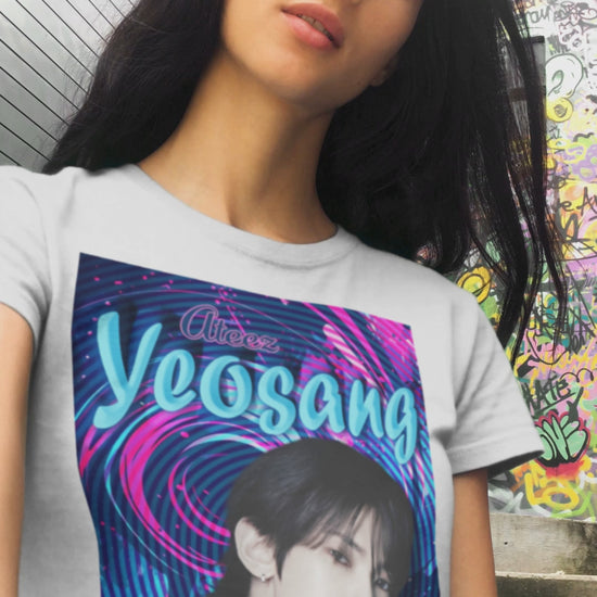 Video showcasing the unisex cotton t-shirt in white, featuring a portrait of Yeosang of ATEEZ surrounded by concentric digital lines and flowing paint-like textures. The design blends graffiti-inspired lettering with koi-like motion in blue lagoon and pink hues. From ModeK Vetements.