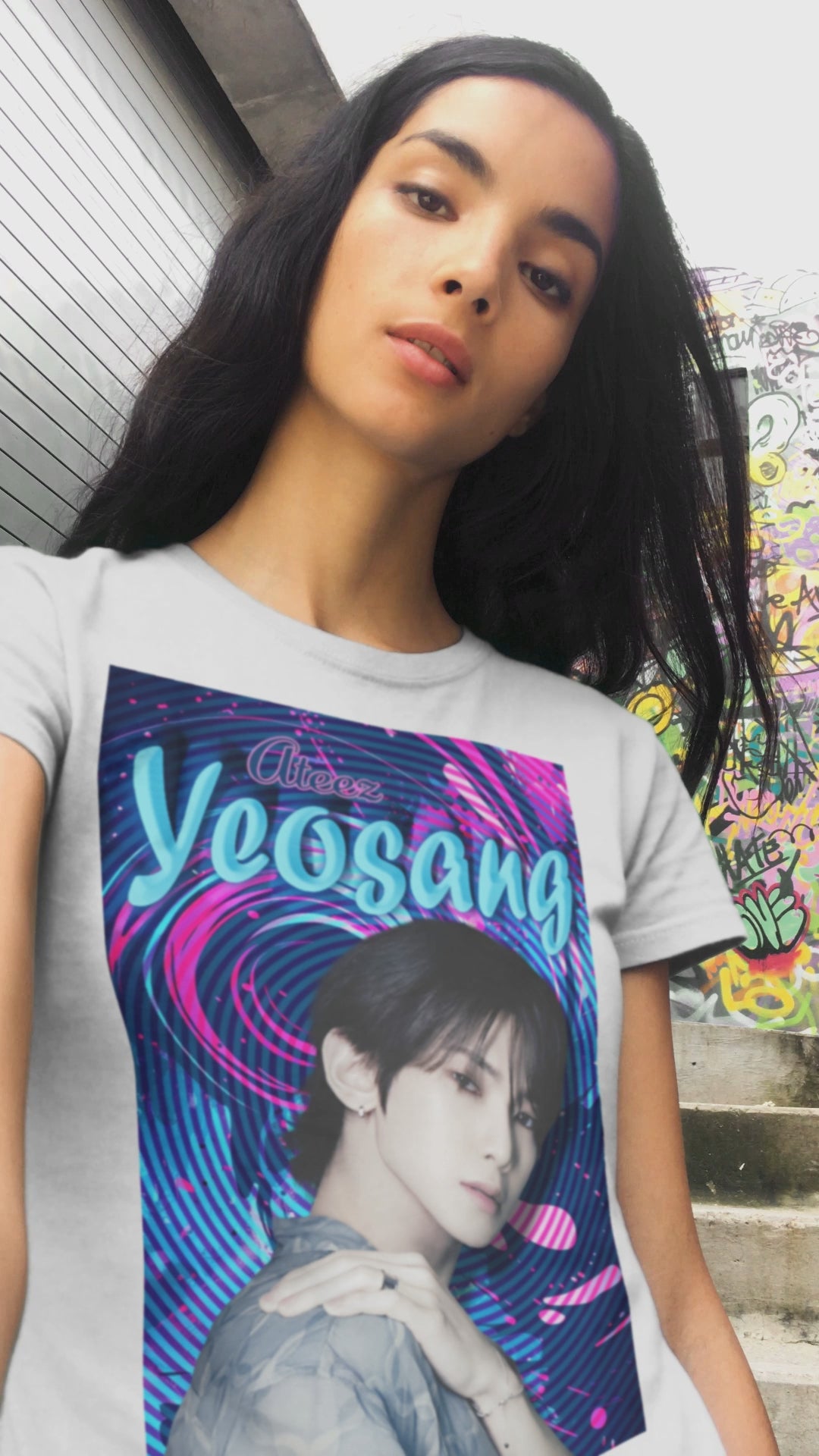 Video showcasing the unisex cotton t-shirt in white, featuring a portrait of Yeosang of ATEEZ surrounded by concentric digital lines and flowing paint-like textures. The design blends graffiti-inspired lettering with koi-like motion in blue lagoon and pink hues. From ModeK Vetements.