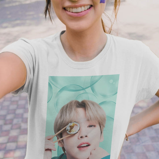 Video showcasing the Lee Know Stray Kids Unisex T-Shirt in white, featuring a playful design with him holding sushi near his eye. The soft mint-green aesthetic enhances his charming and mischievous vibe. Printed on a high-quality cotton tee, available in XS-5XL. ModeK Vetements.