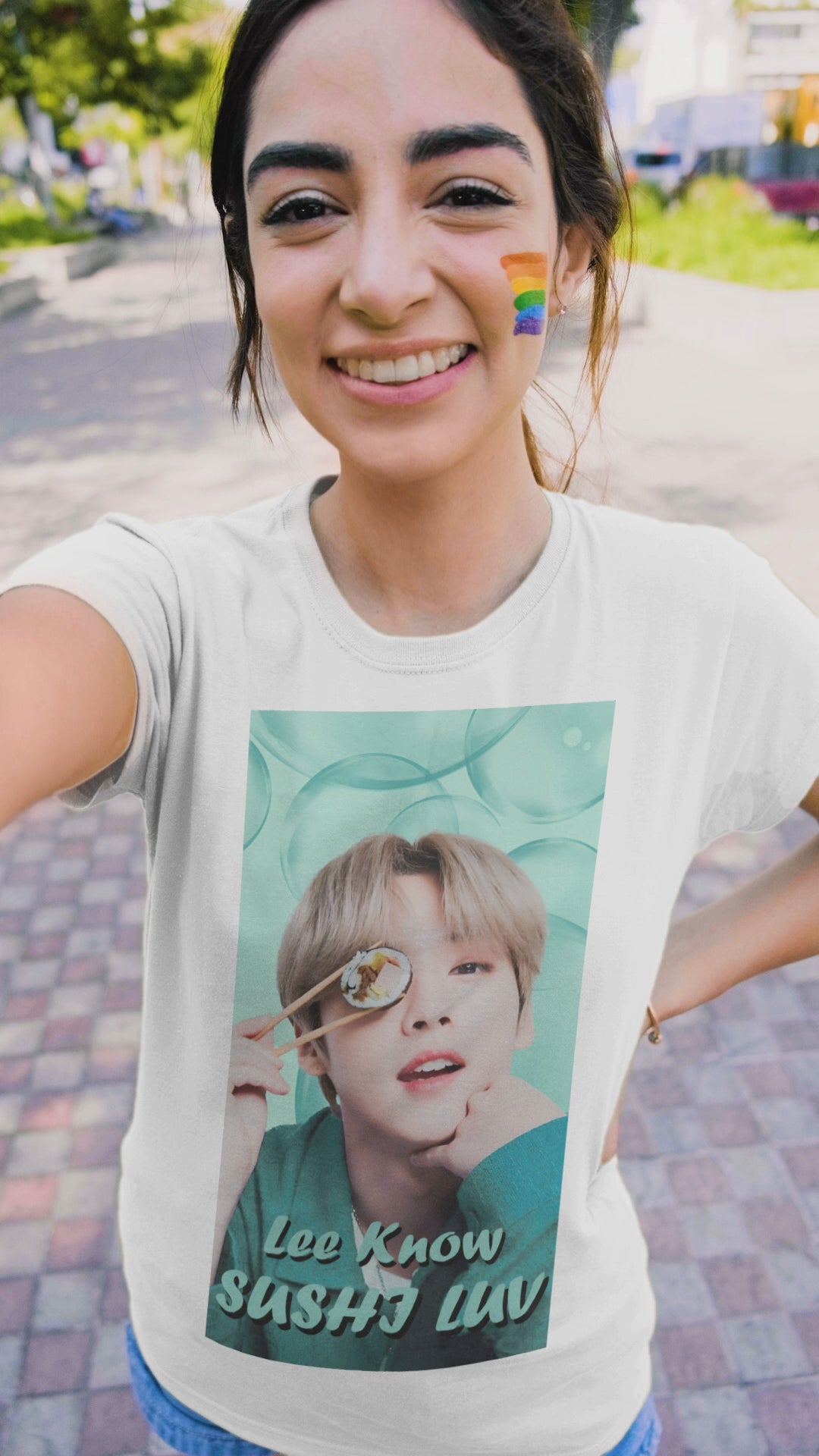 Video showcasing the Lee Know Stray Kids Unisex T-Shirt in white, featuring a playful design with him holding sushi near his eye. The soft mint-green aesthetic enhances his charming and mischievous vibe. Printed on a high-quality cotton tee, available in XS-5XL. ModeK Vetements.