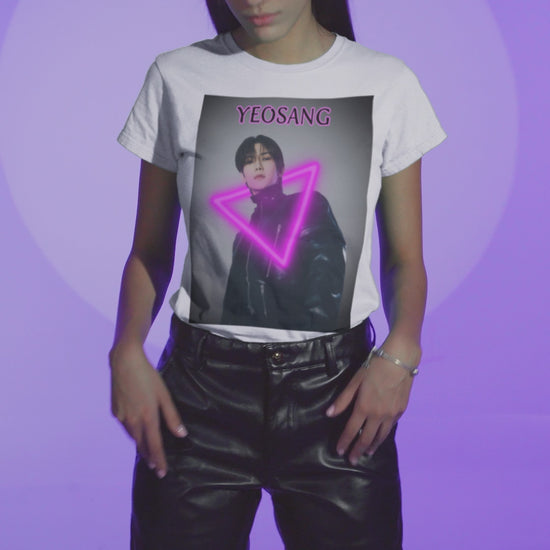 Video showcasing the Unisex cotton t-shirt in white, featuring a centered image of Yeosang from ATEEZ wearing a black leather jacket with multiple gunmetal zippers. A glowing fuchsia neon triangle is layered over his silhouette, creating visual tension between form and light. The name "YEOSANG" appears above in matching pink text. ModeK Vetements.