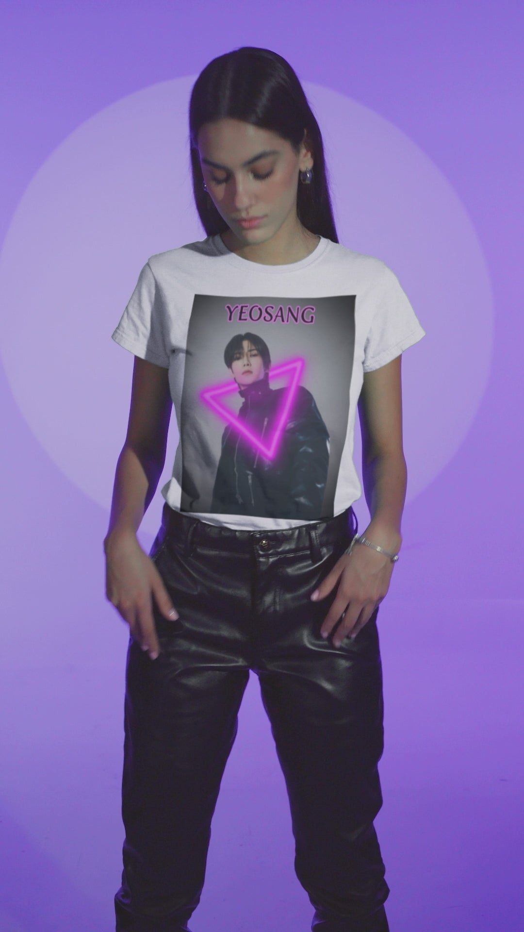 Video showcasing the Unisex cotton t-shirt in white, featuring a centered image of Yeosang from ATEEZ wearing a black leather jacket with multiple gunmetal zippers. A glowing fuchsia neon triangle is layered over his silhouette, creating visual tension between form and light. The name "YEOSANG" appears above in matching pink text. ModeK Vetements.