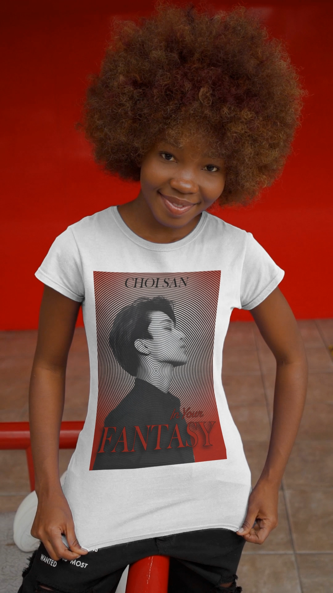 Video showcasing Choi San ATEEZ in profile, surrounded by a hypnotic circular pattern centered on his neck, with a platinum-to-blood-red gradient and bold In Your Fantasy lettering on unisex cotton t-shirt in white. From ModeK Vetements.