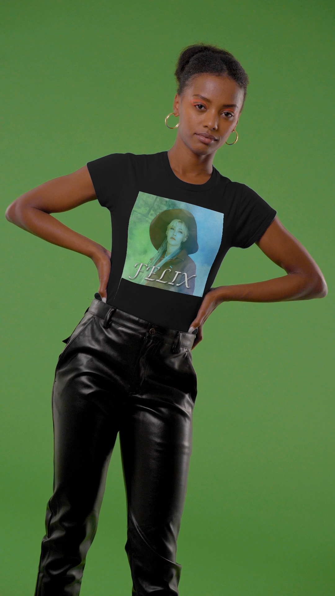 Video showcasing the unisex 100% ring-spun cotton T-Shirt in black, featuring a portrait of Stray Kids' Felix wearing a large hat. It is as if he was painted on canvas with the effect of a mist, blending soft light blue and light green tones. From ModeK Vetements.