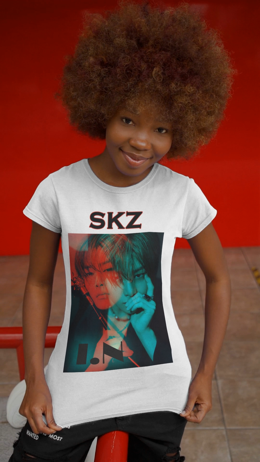 Video showcasing the I.N Stray Kids unisex T-shirt in white, featuring a bold black-and-white portrait with a dual-tone red and teal overlay. The striking 3D-like effect, combined with "SKZ" typography and I.N’s name, creates a modern, edgy aesthetic. Made from 100% cotton for lightweight comfort. From ModeKVetements.