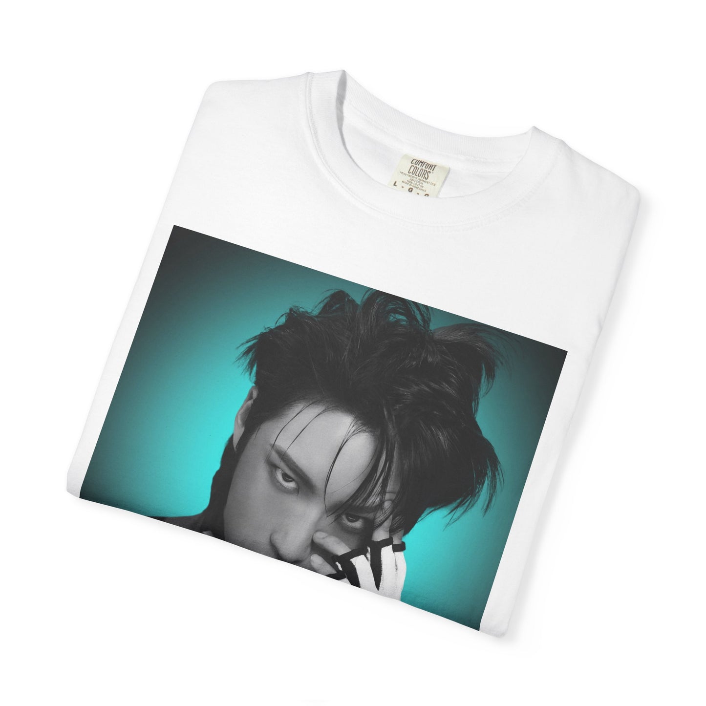 Folded Seonghwa ATEEZ Unisex T-Shirt in white – Experiment in Contrasts. A striking black-and-white portrait of Seonghwa with dramatic lighting, deep shadows, and a piercing gaze. His darkened lips add an intense edge, while a bold teal glow surrounds him, creating a contrast between elegance and raw energy. ModeK Vetements.