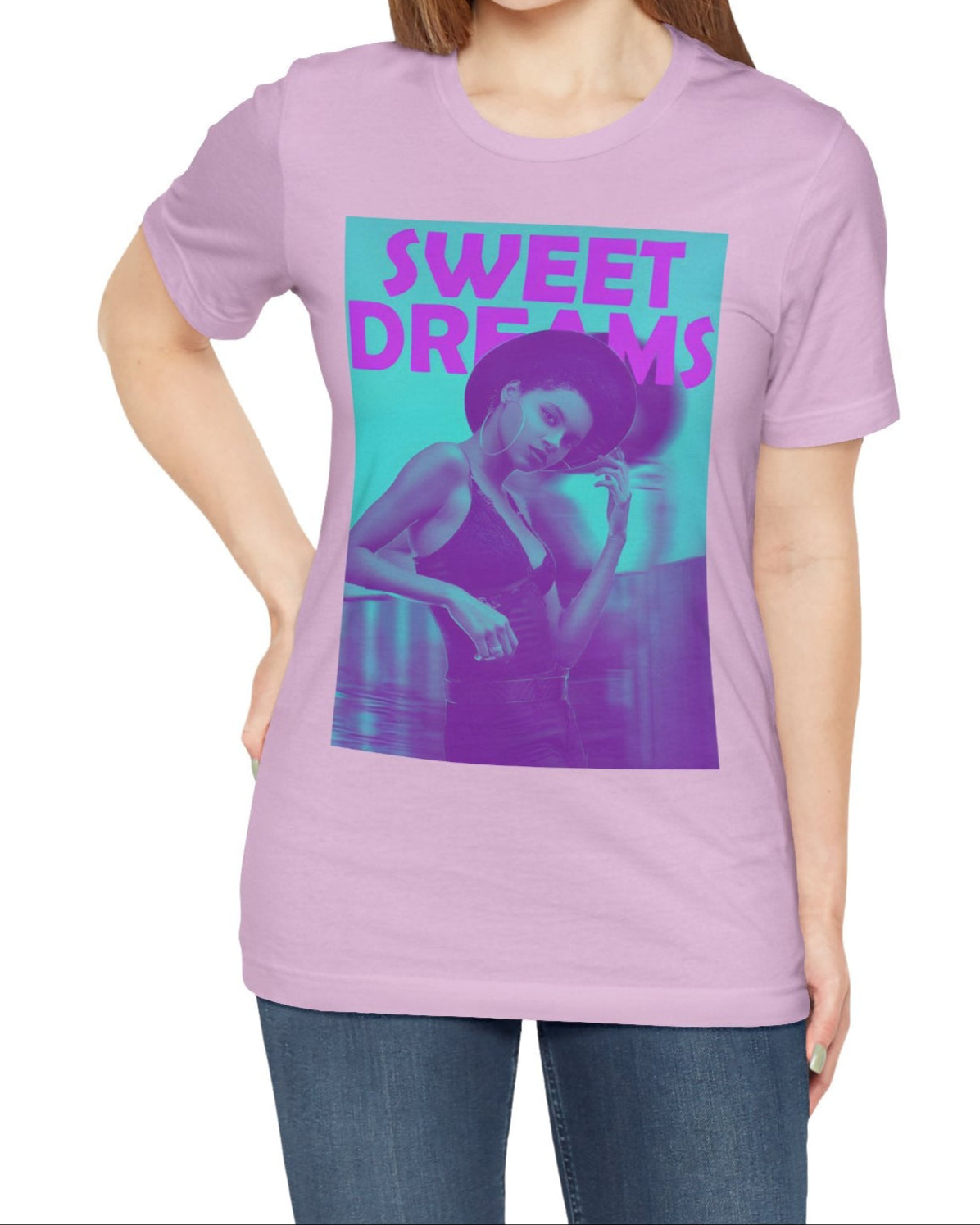 Unisex airlume cotton t-shirt in lilac, featuring a woman in a wide-brimmed hat appearing clearly over a blurred motion version of herself, as if caught between dream and sleep. The lilac-pink words “SWEET DREAMS” float above on a medium turquoise background, evoking the gentle melancholy of May evenings. From ModeK Vetements.