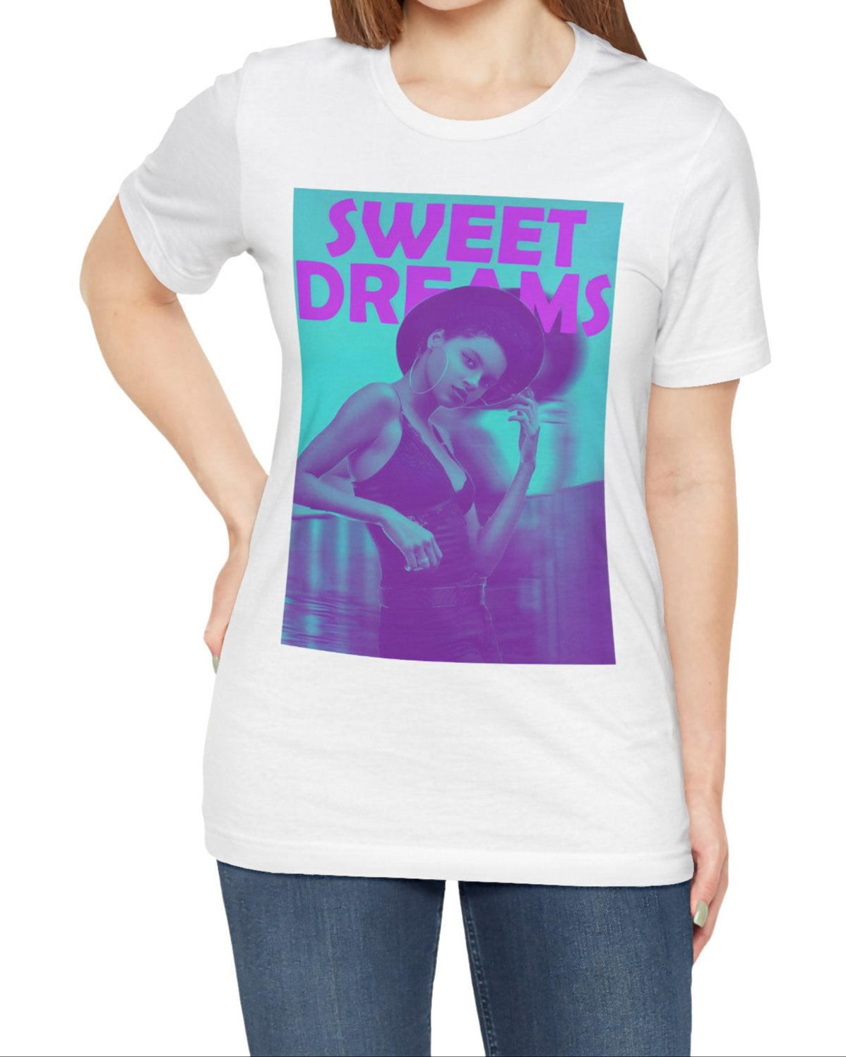 Unisex airlume cotton t-shirt in white, featuring a woman in a wide-brimmed hat appearing clearly over a blurred motion version of herself, as if caught between dream and sleep. The lilac-pink words “SWEET DREAMS” float above on a medium turquoise background, evoking the gentle melancholy of May evenings. From ModeK Vetements.