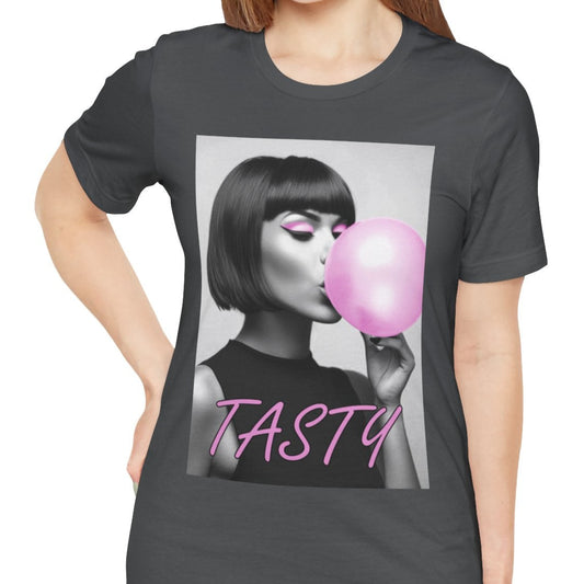 Stylized black-and-white portrait of a woman with a bob haircut blowing a bright pink bubblegum bubble, printed on a T-shirt in asphalt, with the word “TASTY” in pink script. ModeK Vetements.