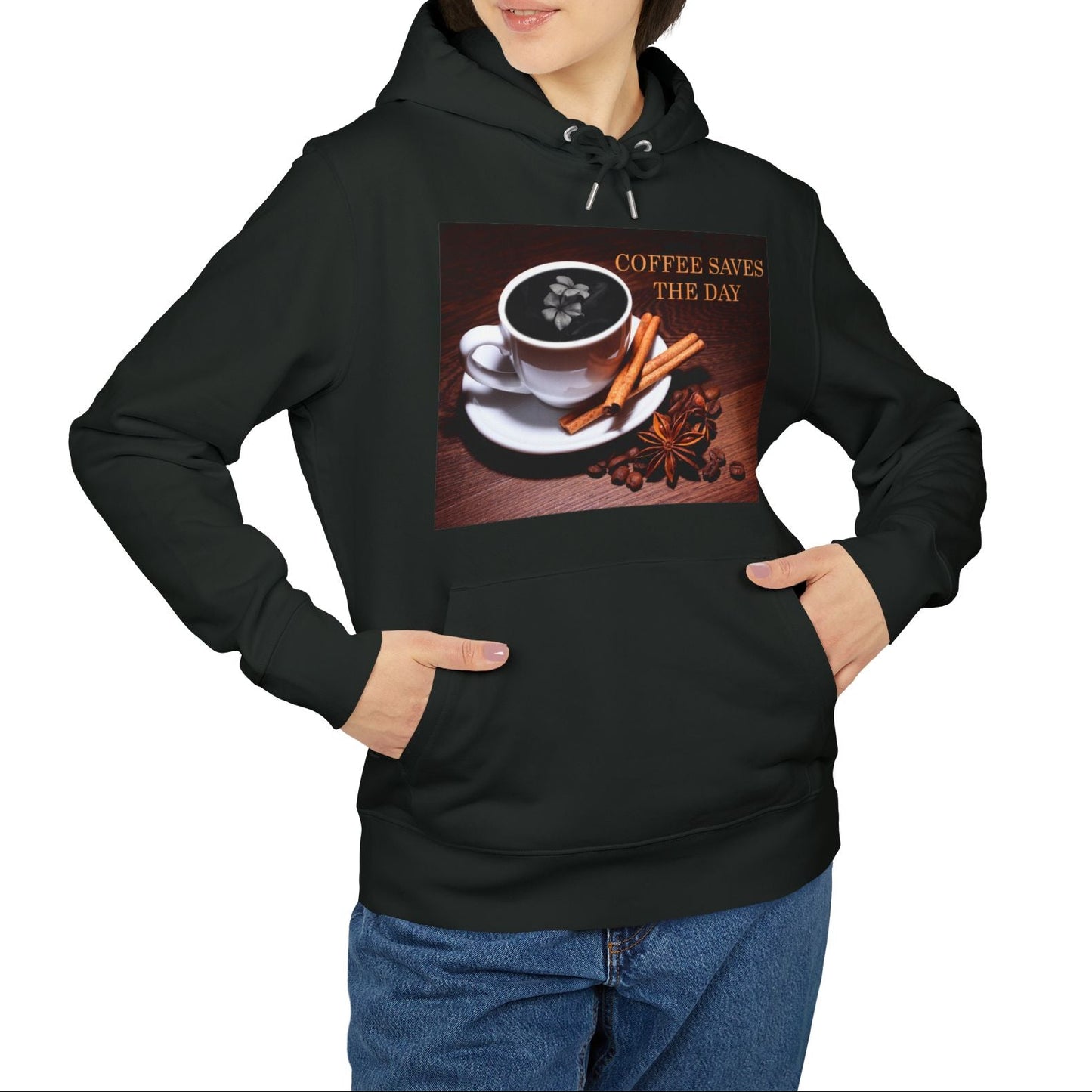 Unisex hoodie in black, with front graphic showing a white porcelain coffee cup surrounded by cinnamon sticks, star anise, and coffee beans, with a dark foam surface blooming into a subtle flower shape. 100% organic, combed and ring-spun cotton from ModeK Vetements.