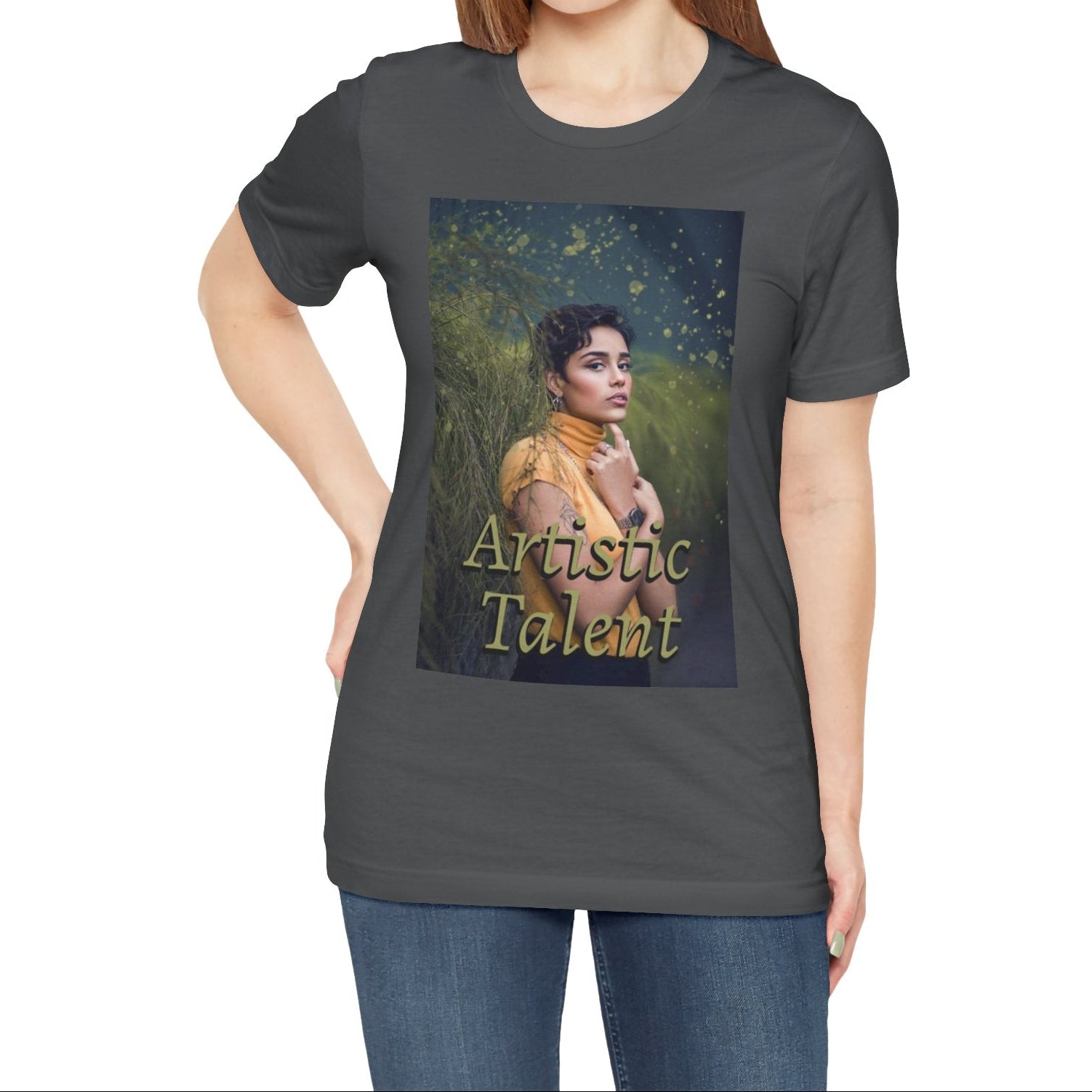 Unisex 100% airlume combed and ring-spun cotton t-shirt in asphalt featuring a woman in a yellow turtleneck. The image is layered with golden paint splashes creating a sense of motion and "Artistic Talent" where the subject looks real enough to step out of the picture. From ModeK Vetements.