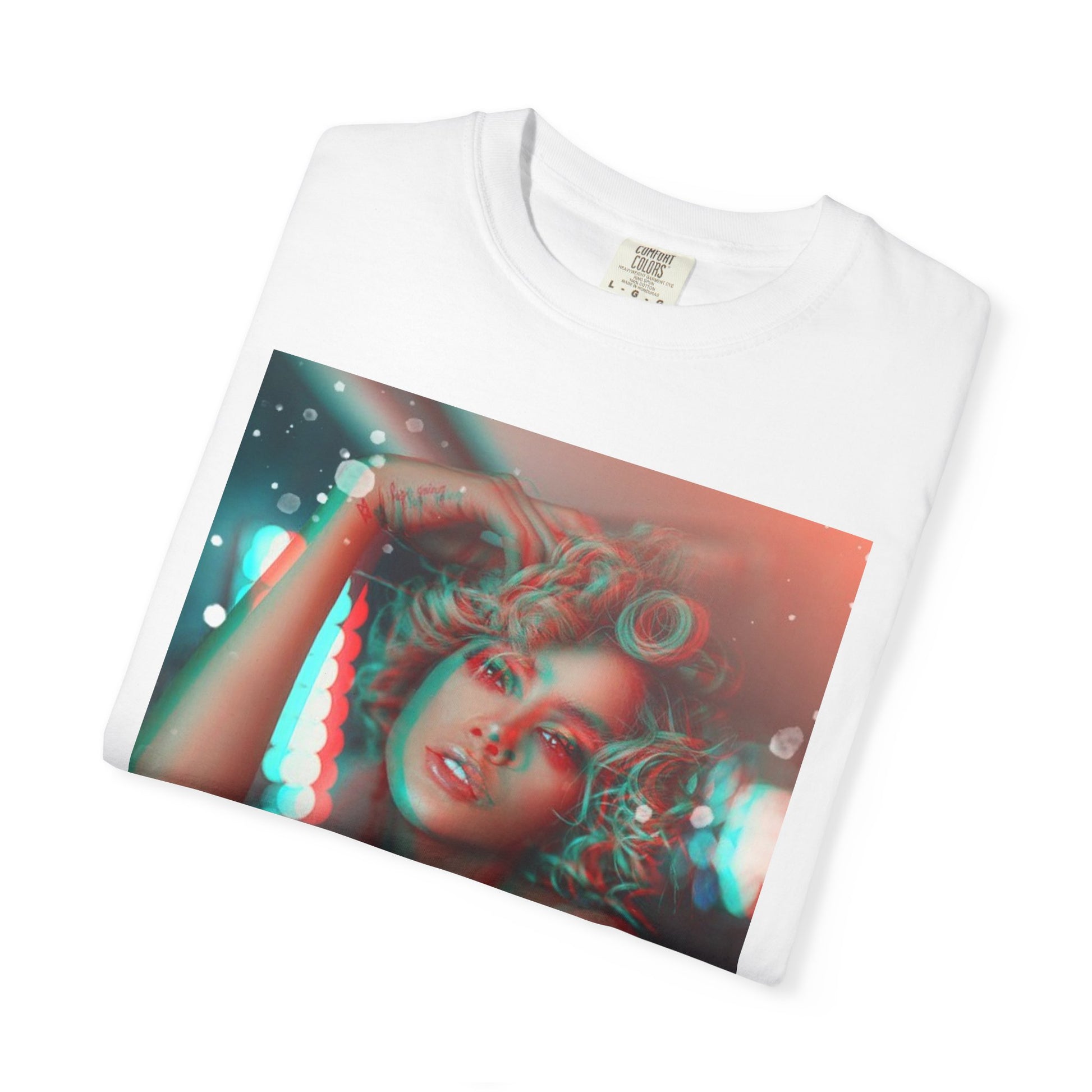 Folded Unisex 100% ring-spun cotton T-Shirt in white featuring a DTG graphic design: a stylized anaglyph portrait of a woman with curly hair, leaning on an electronic keyboard. The design uses a 3D glitch effect with shifting layers of electric blue and bittersweet red-orange, capturing a "DREAMY" cinematic atmosphere. From ModeK Vetements.