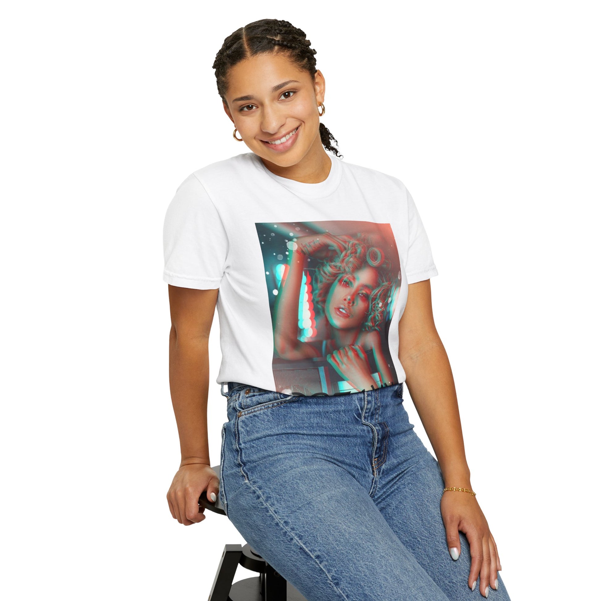 Model sitting on a chair and wearing the unisex 100% ring-spun cotton T-Shirt in white featuring a DTG graphic design: a stylized anaglyph portrait of a woman with curly hair, leaning on an electronic keyboard. The design uses a 3D glitch effect with shifting layers of electric blue and bittersweet red-orange, capturing a "DREAMY" cinematic atmosphere. From ModeK Vetements.