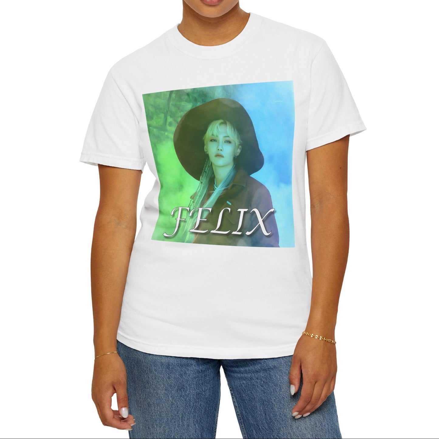 Unisex 100% ring-spun cotton T-Shirt in white, featuring a portrait of Stray Kids' Felix wearing a large hat. It is as if he was painted on canvas with the effect of a mist, blending soft light blue and light green tones. From ModeK Vetements.