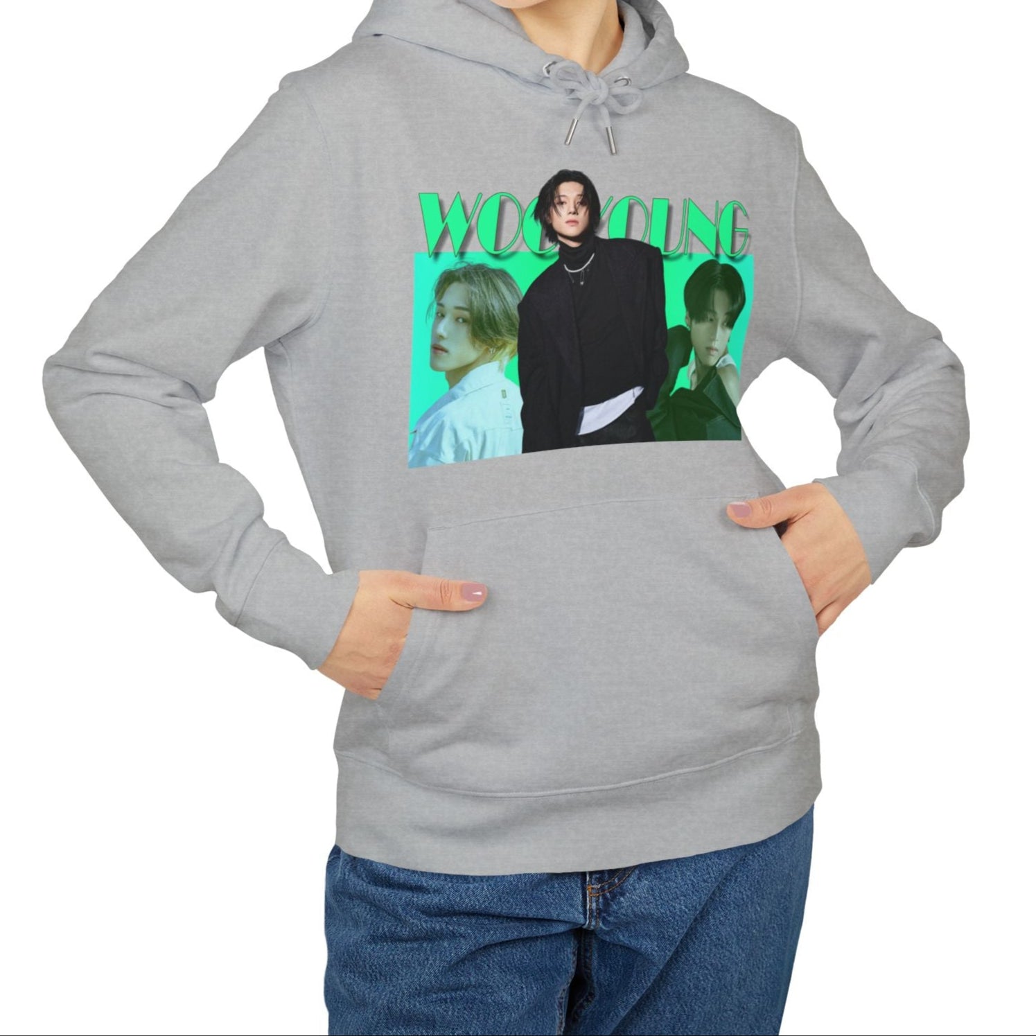 Unisex hoodie in heather grey, from 100% organic cotton, featuring a photo collage of ATEEZ’s Wooyoung. The central full-body image shows him in a black jacket with a pearl necklace and three safety pins, stepping forward over two bust-level side portraits. Background fades from aquamarine to green-cyan, with bold wintergreen “WOOYOUNG” text above. ModeK Vetements.