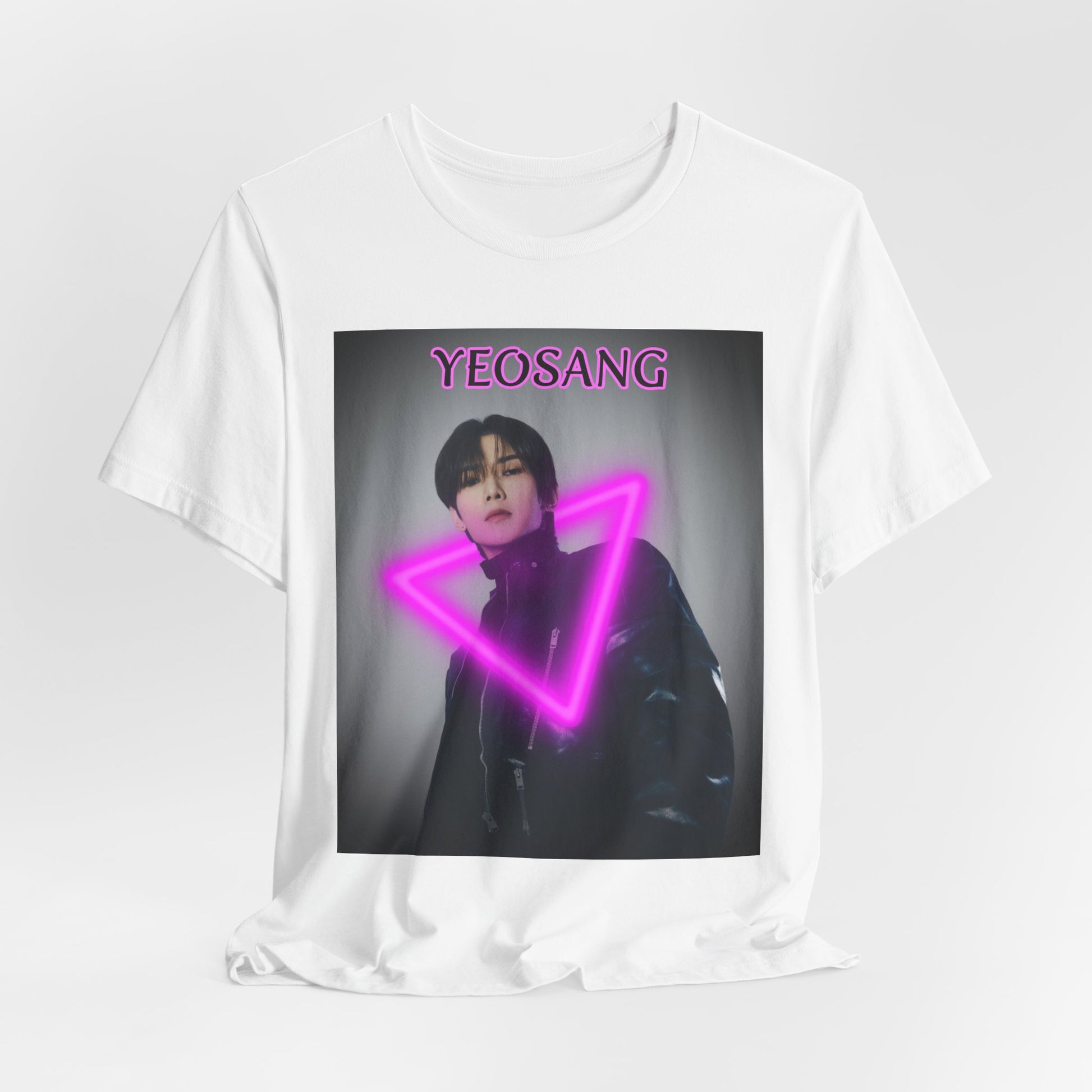 Draped Unisex cotton t-shirt in white, featuring a centered image of Yeosang from ATEEZ wearing a black leather jacket with multiple gunmetal zippers. A glowing fuchsia neon triangle is layered over his silhouette, creating visual tension between form and light. The name "YEOSANG" appears above in matching pink text. ModeK Vetements.