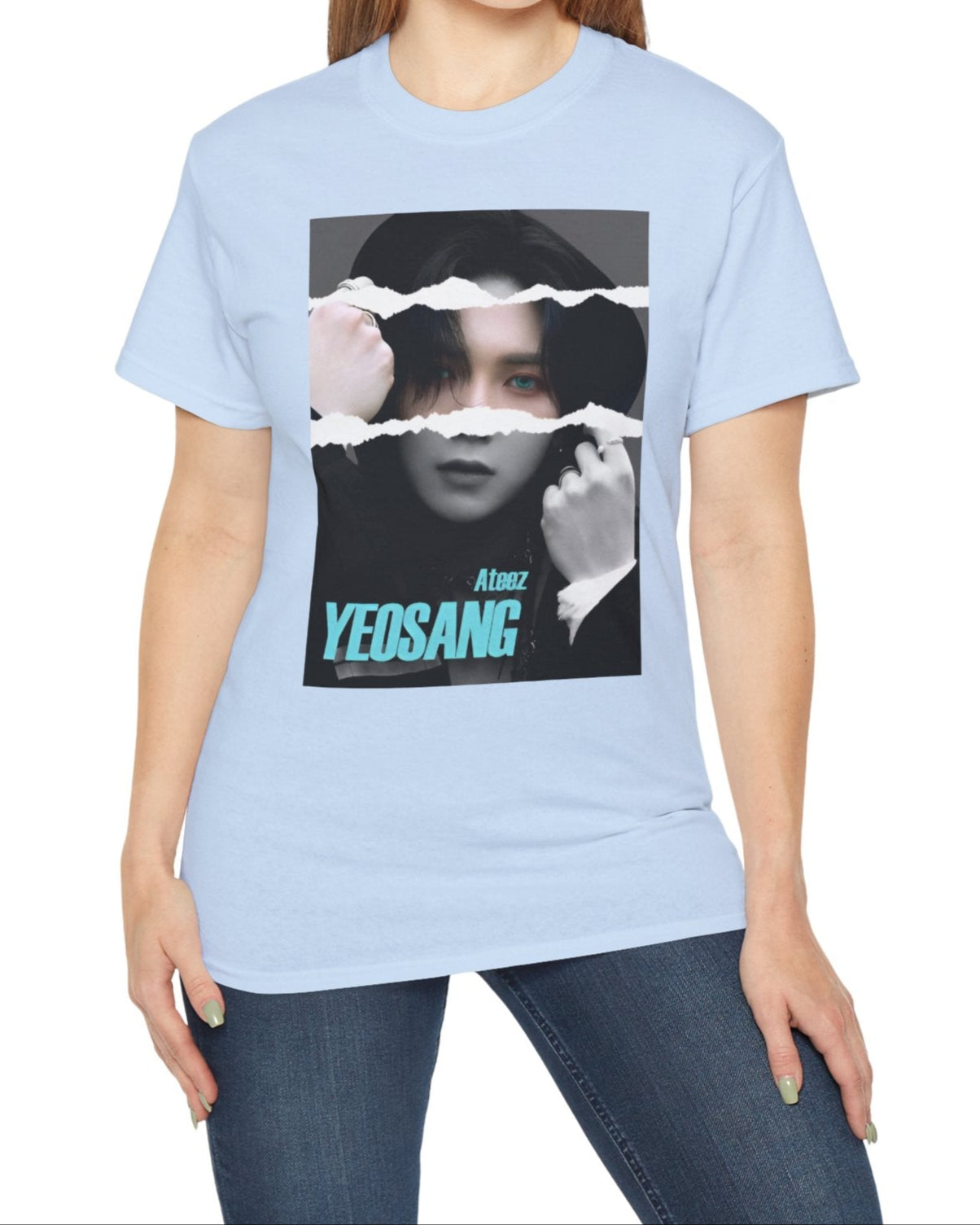 Yeosang ATEEZ graphic unisex t-shirt in light blue, with a black-and-white portrait featuring a torn-paper effect revealing a single colored strip with turquoise eyes and text. Yeosang is putting a hoodie over his head, creating a quiet, enigmatic presence. From ModeKVetements.