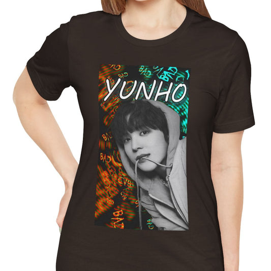 Unisex airlume combed & ring-spun cotton t-shirt in brown, featuring Yunho of ATEEZ in monochrome, biting a drawcord, as glitchy concentric ripples pulse around him. Ferrari red melts into aqua and green — a tempest of color and emotion, suspended mid-thought. From ModeKVetements.