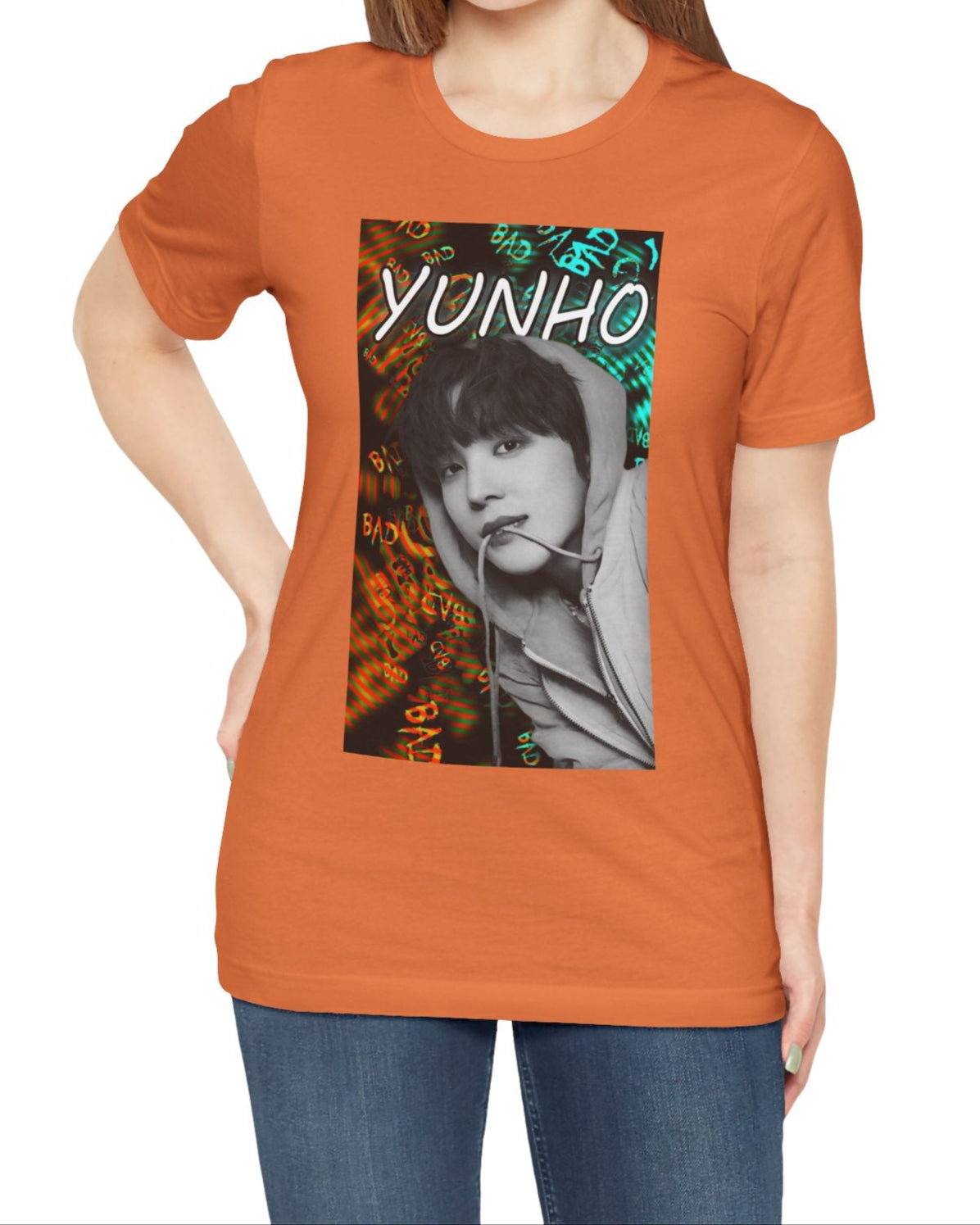 Unisex airlume combed & ring-spun cotton t-shirt in burnt orange, featuring Yunho of ATEEZ in monochrome, biting a drawcord, as glitchy concentric ripples pulse around him. Ferrari red melts into aqua and green — a tempest of color and emotion, suspended mid-thought. From ModeKVetements.
